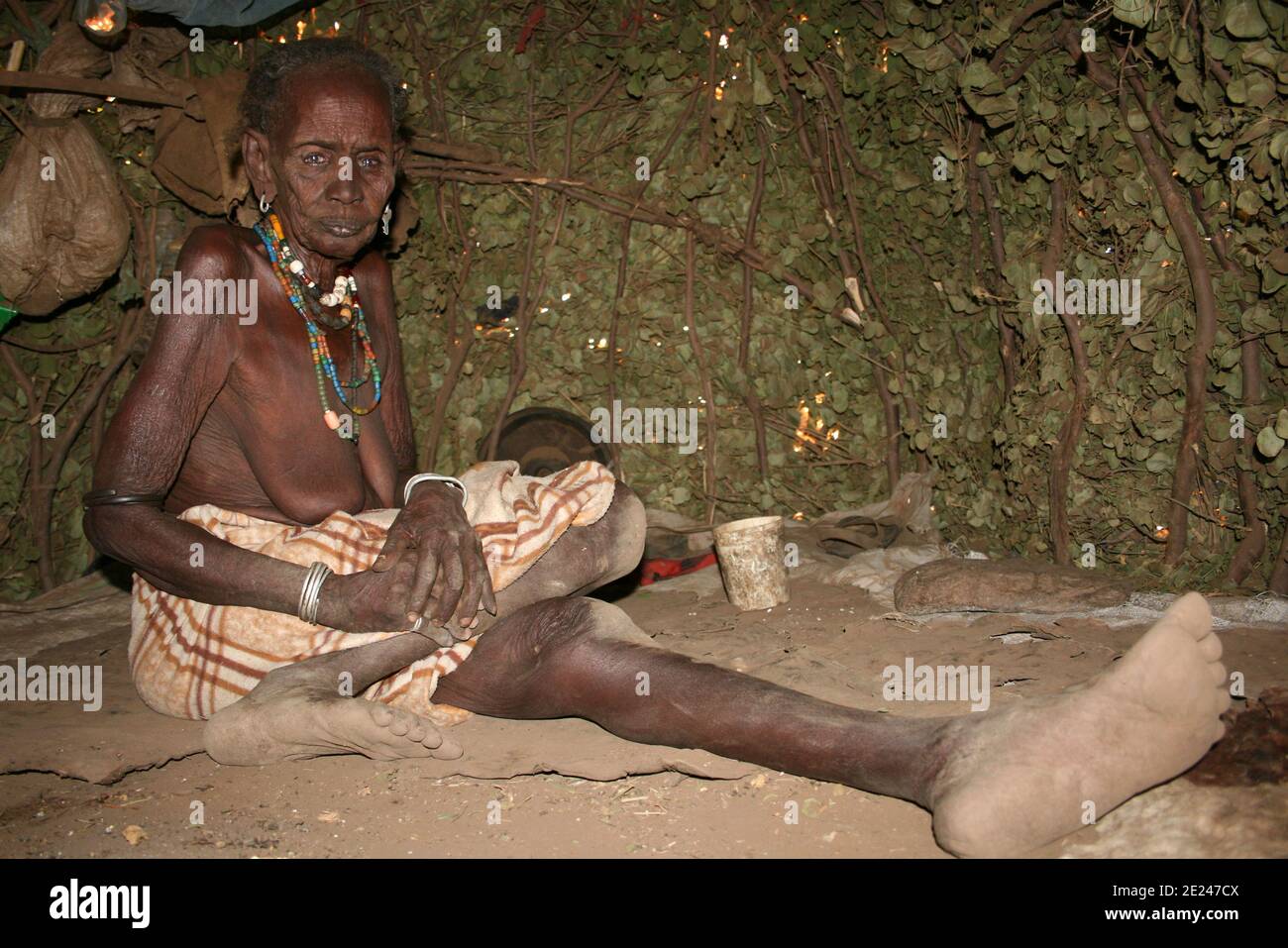 Anziano Dassanech Tribe Donna dentro Rifugio, Omo Rati, Etiopia Foto Stock