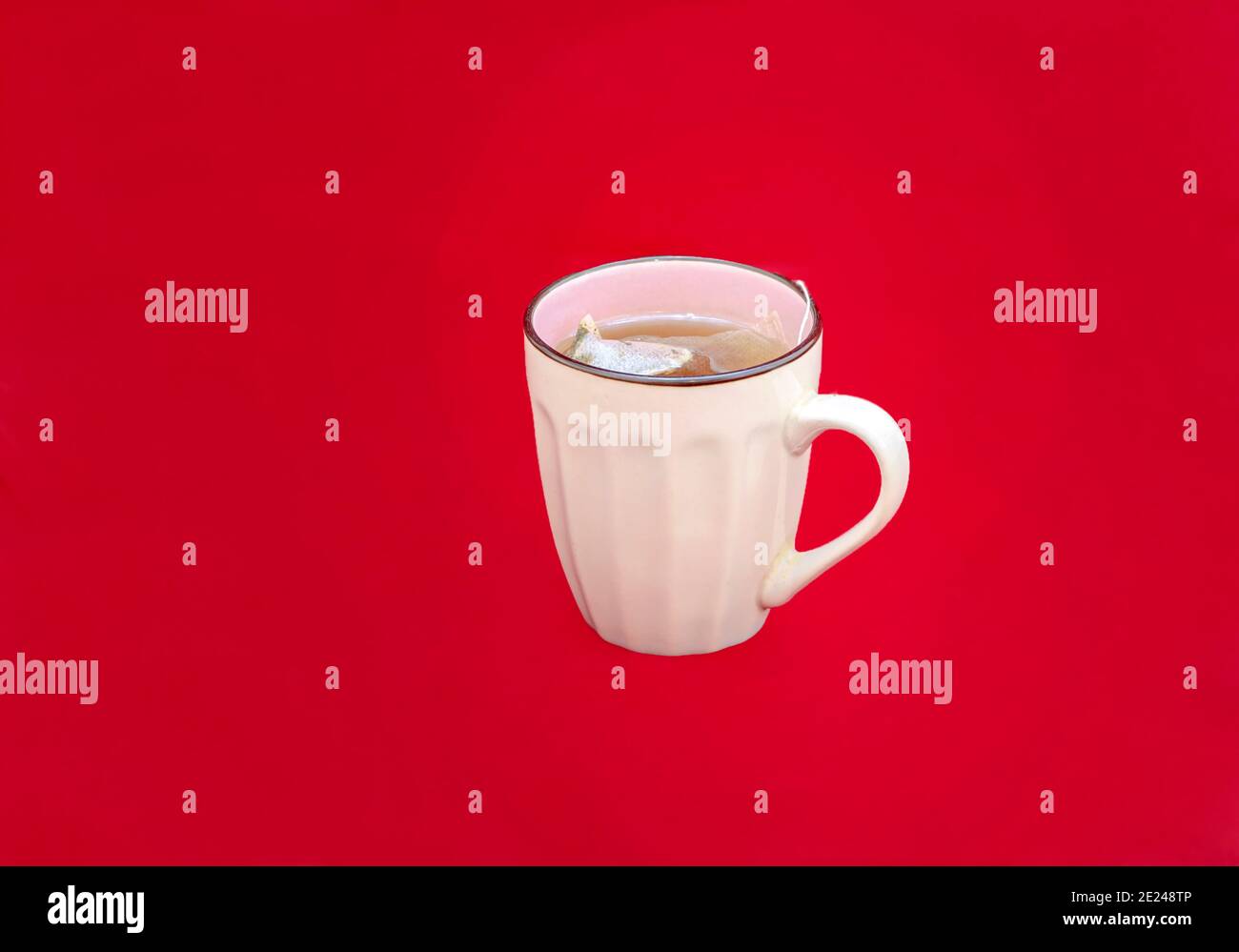 tè verde con tazza bianca al limone su sfondo rosso Foto Stock
