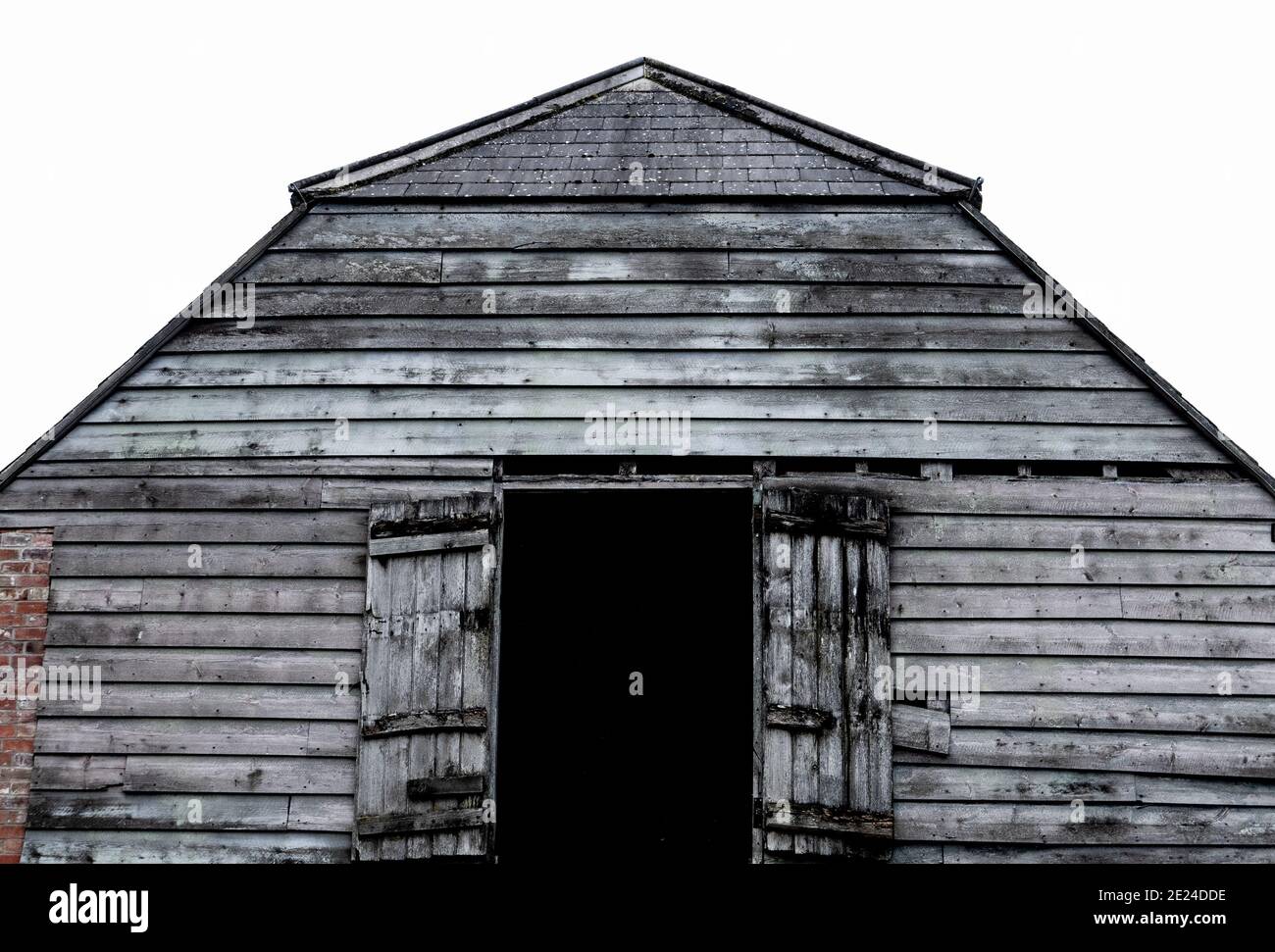 Vecchio fienile in mattoni e legno con porte di carico al primo piano a Westbury, Wiltshire, Inghilterra, Regno Unito. Foto Stock