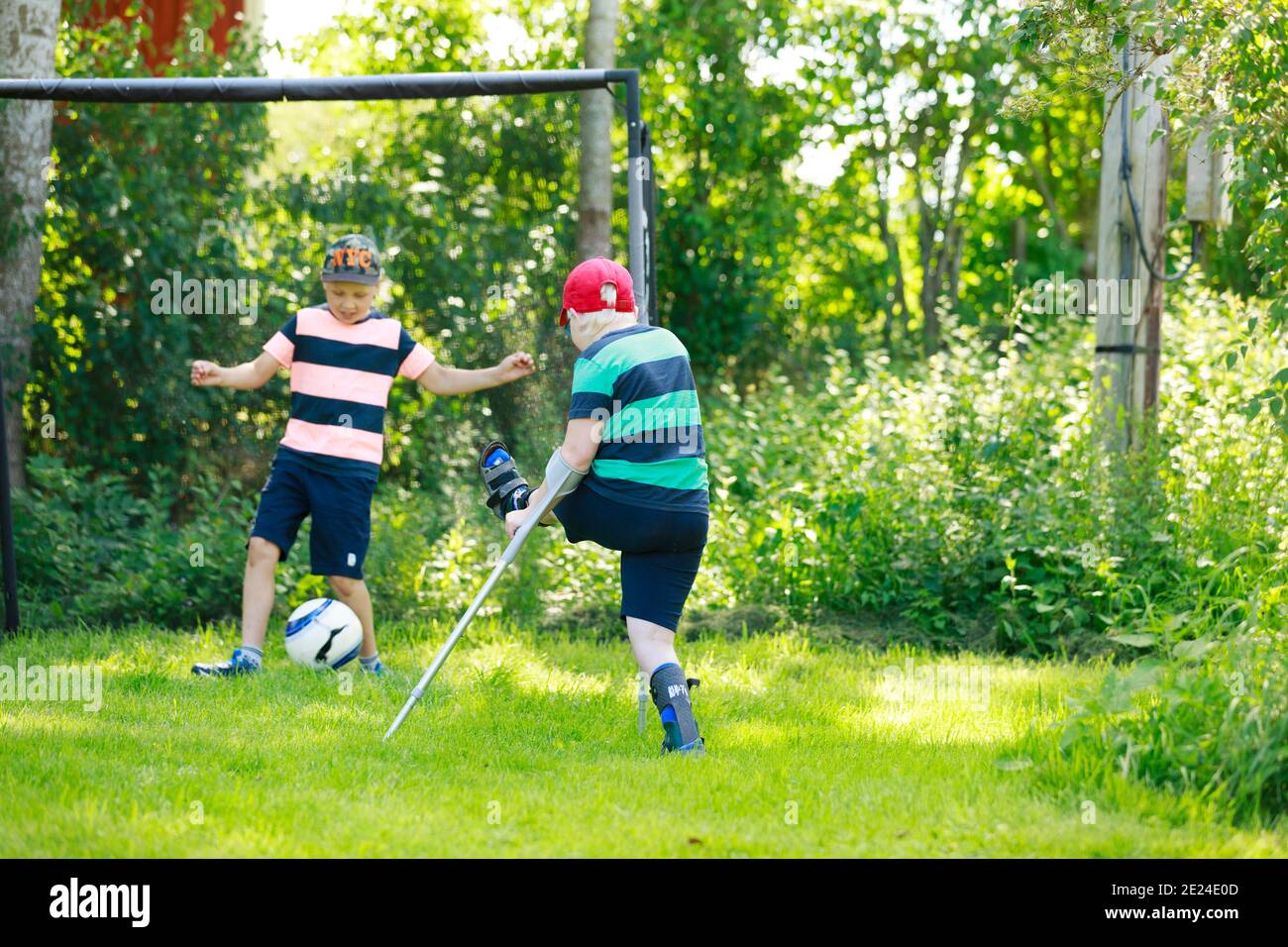 Ragazzo giocando a calcio in giardino Foto Stock