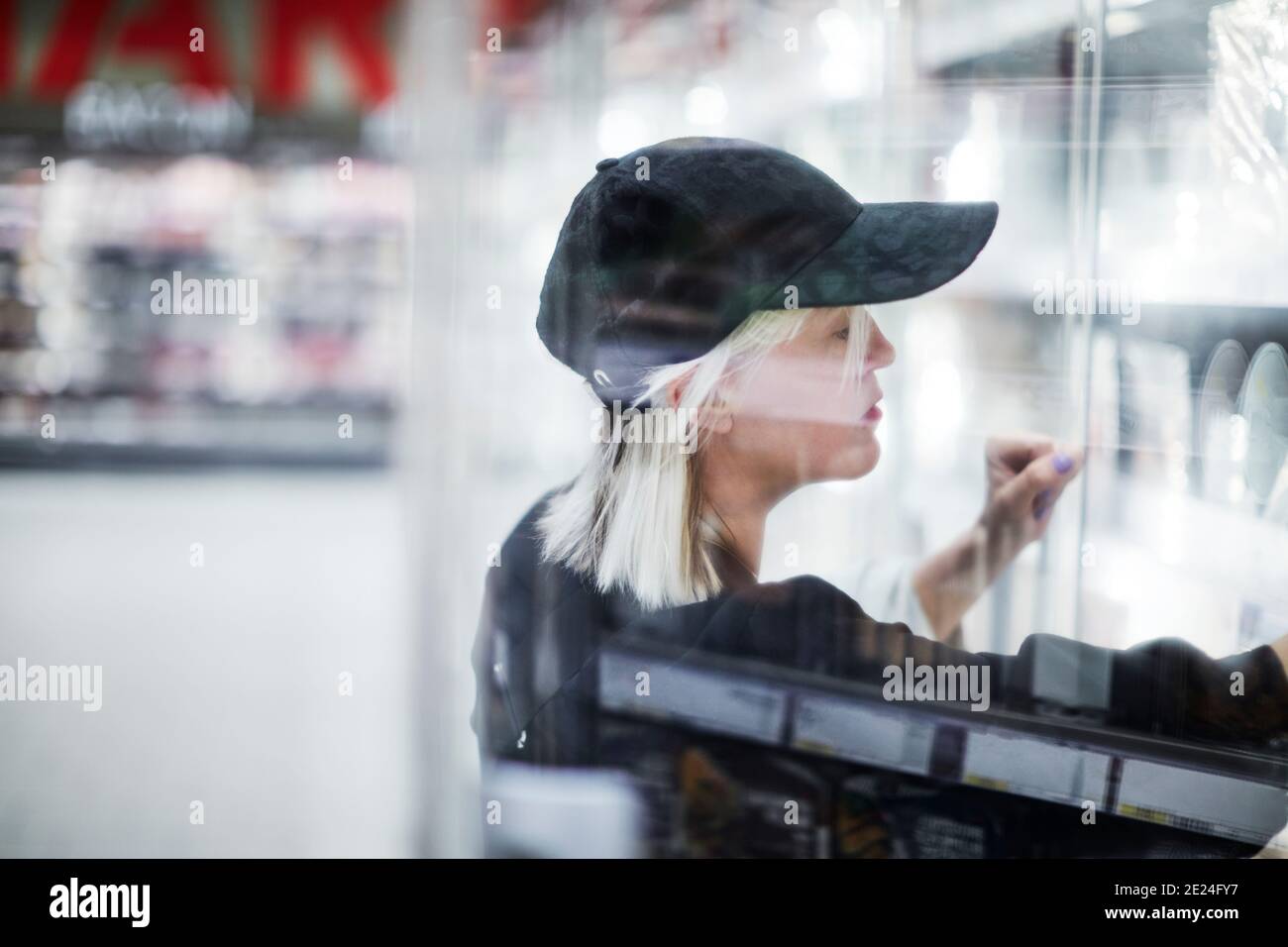 Donna che guarda gli scaffali in negozio Foto Stock