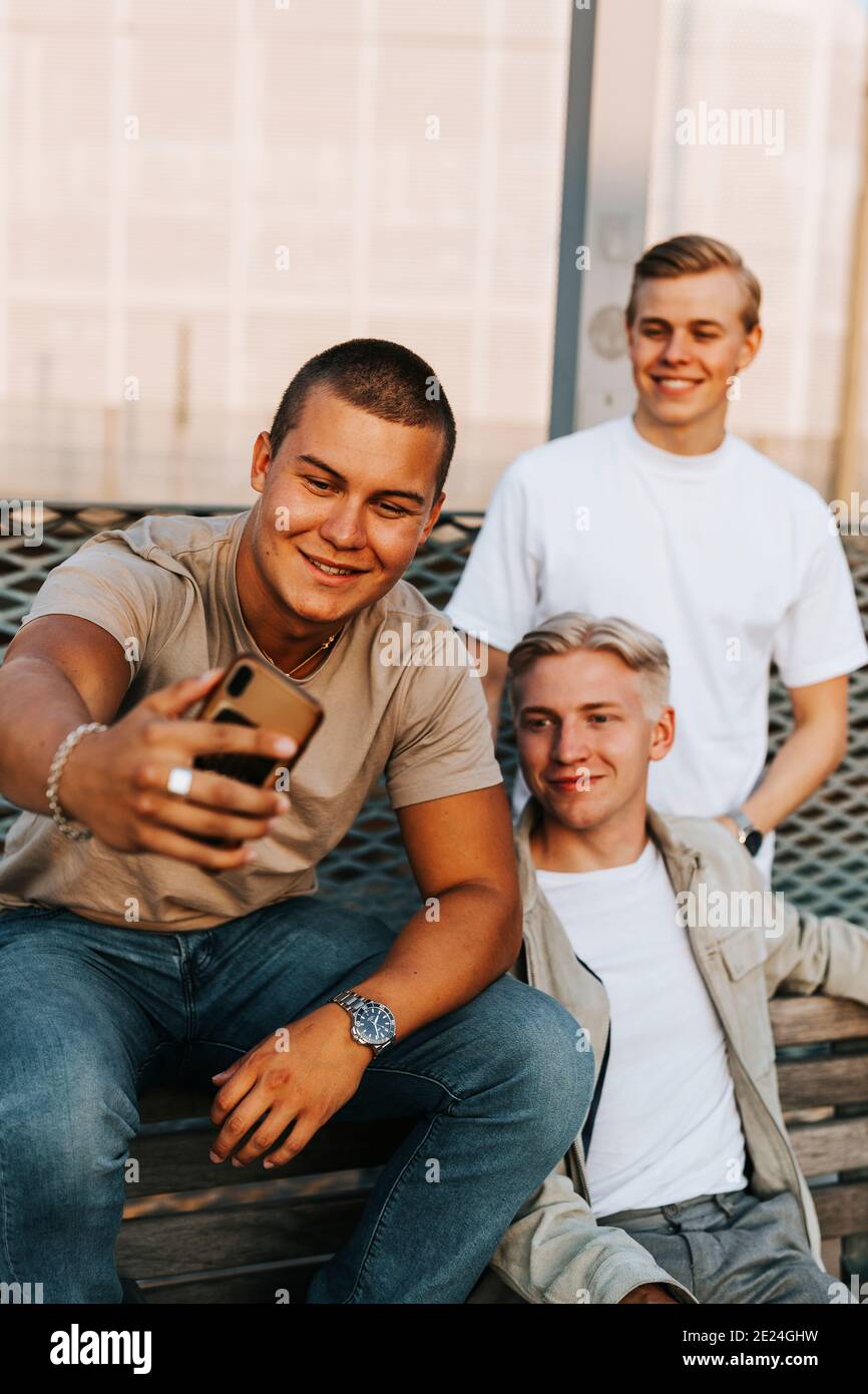 Amici maschi che prendono selfie Foto Stock