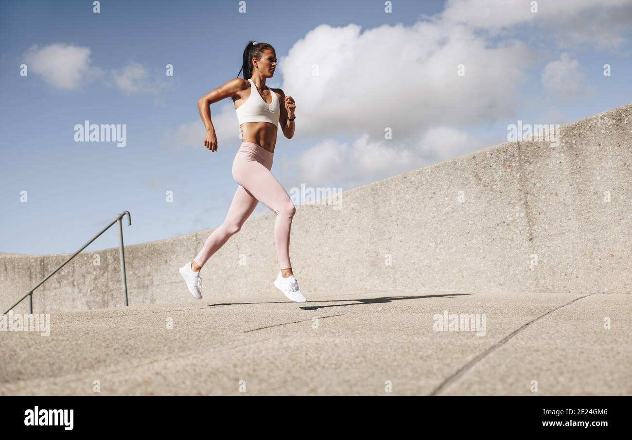 Atleta che corre al mattino. Donna in forma fisica indossare allenamento all'aperto. Foto Stock