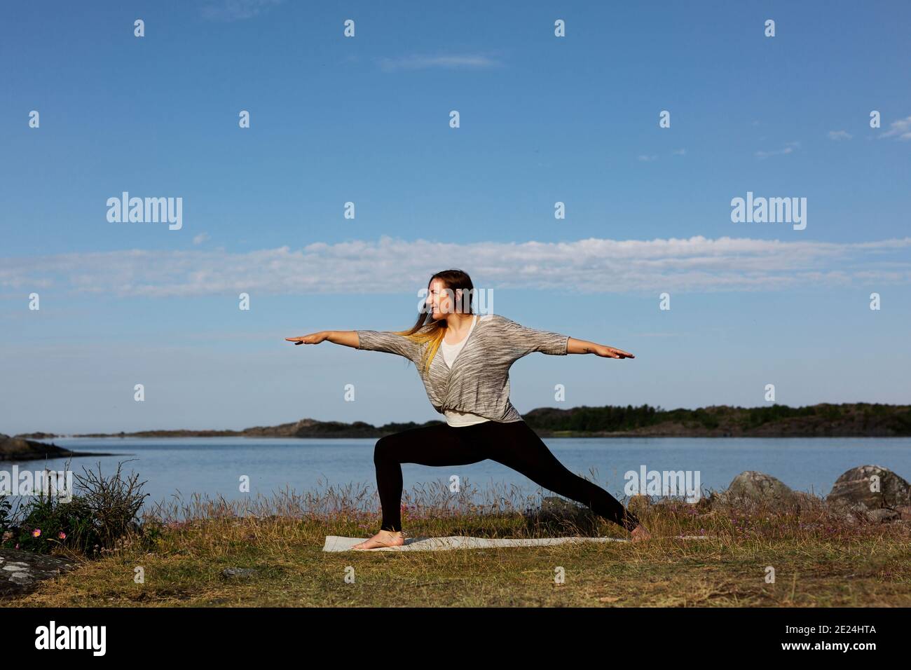 Donna fare yoga in mare Foto Stock