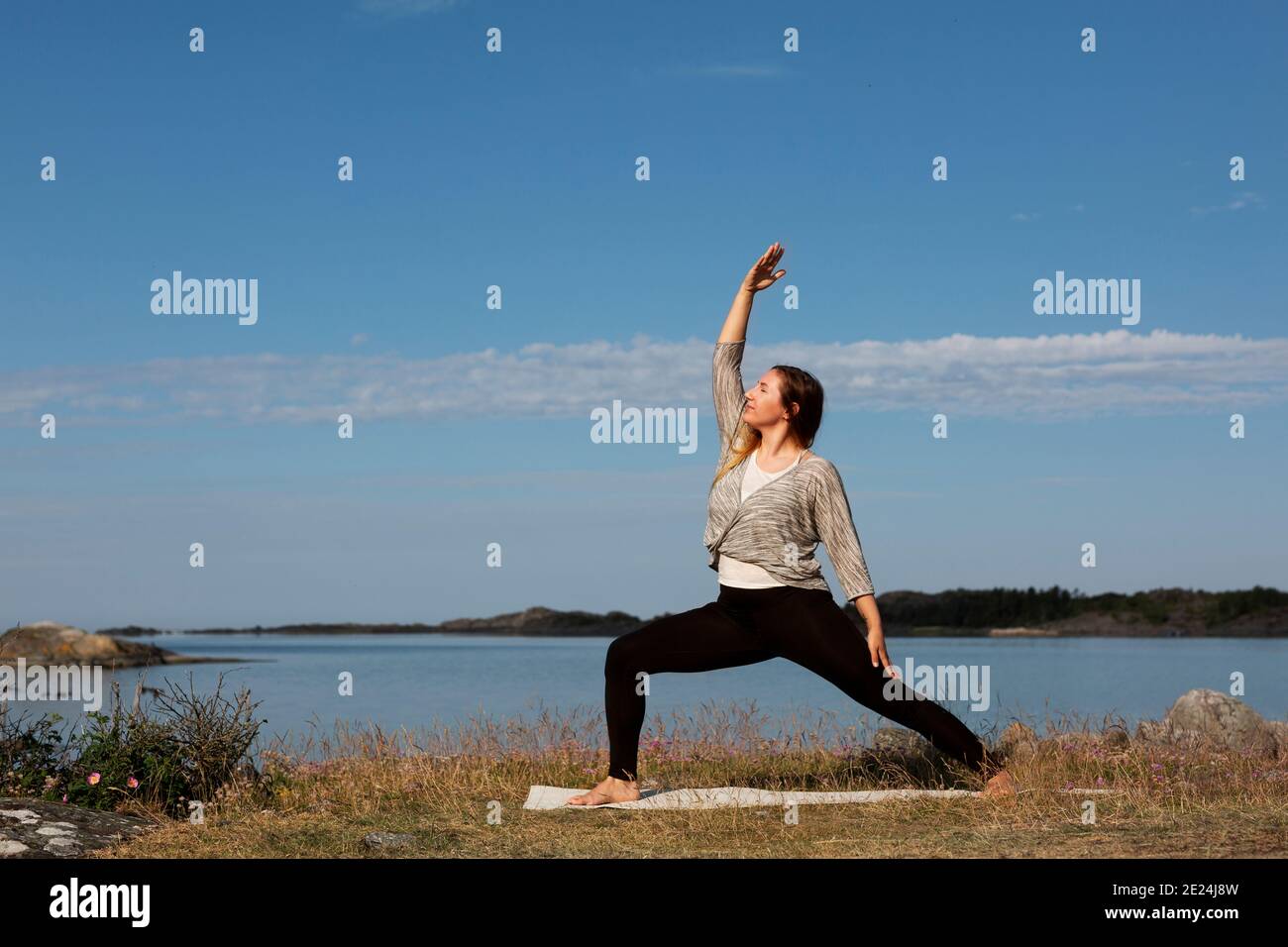 Donna fare yoga in mare Foto Stock