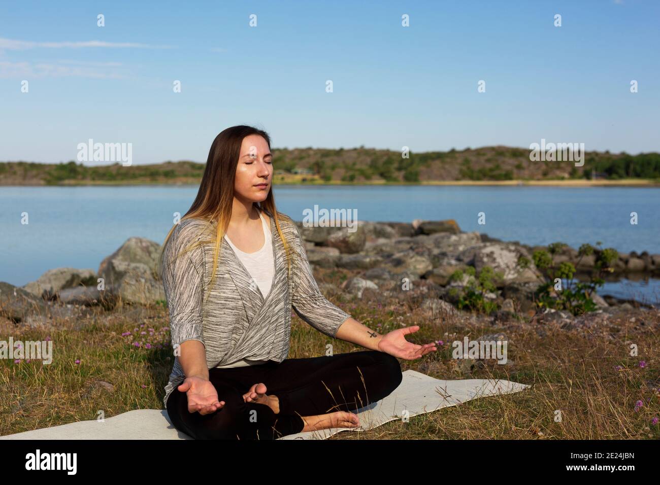Donna meditando in mare Foto Stock