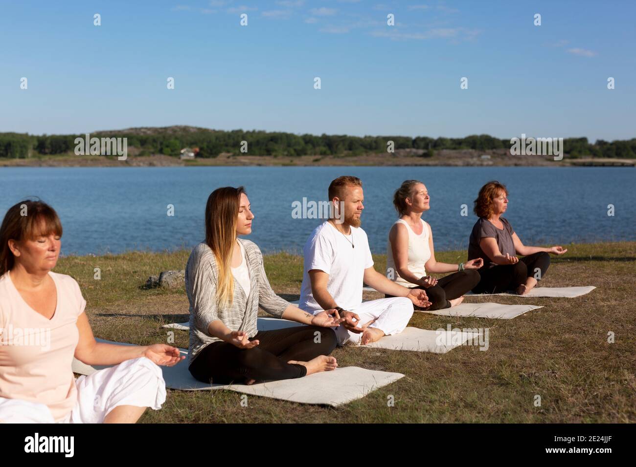 Persone che meditano in mare Foto Stock
