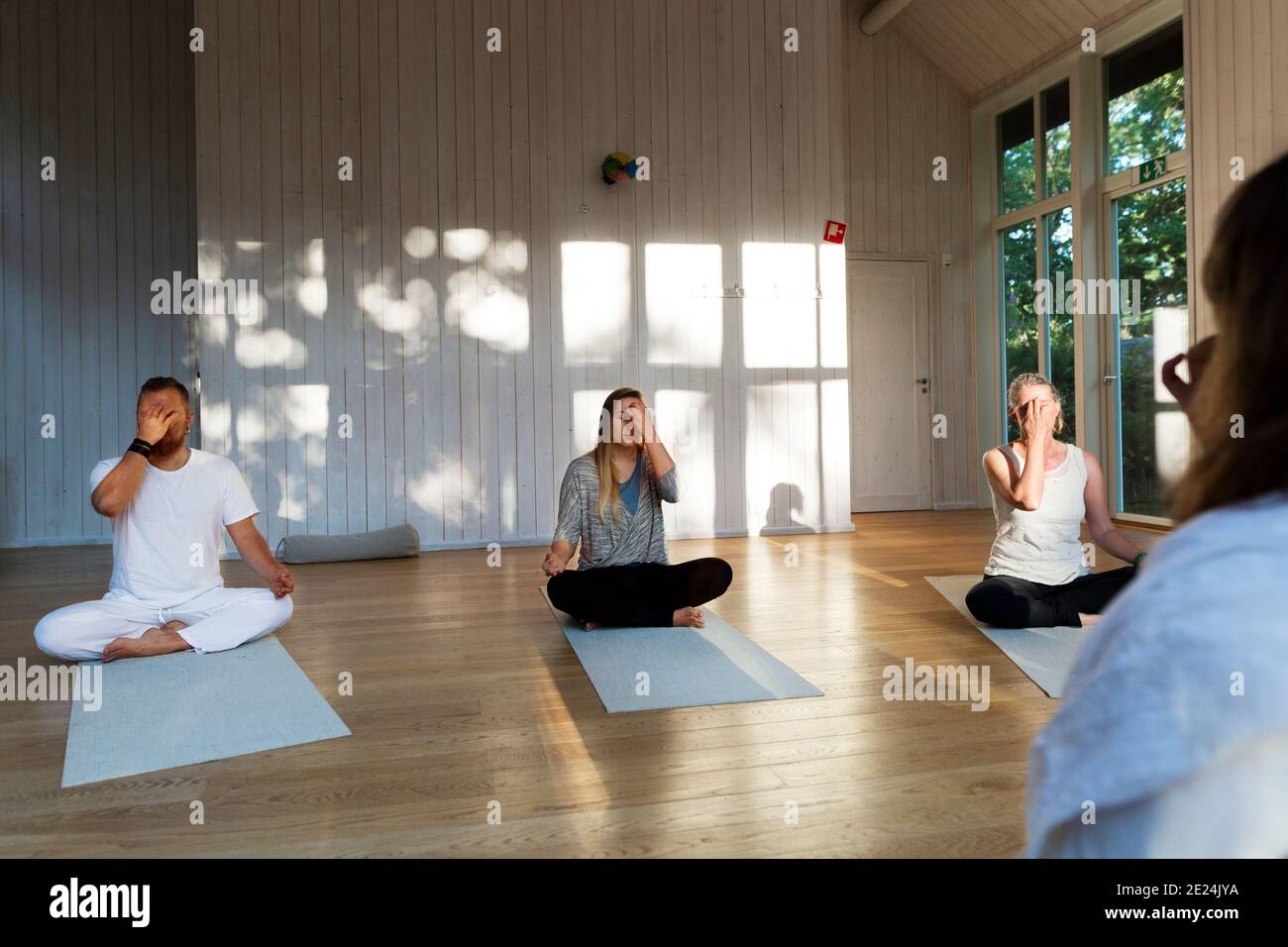 Persone che praticano lo yoga in classe Foto Stock