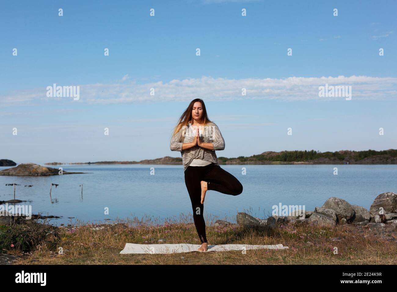 Donna fare yoga in mare Foto Stock