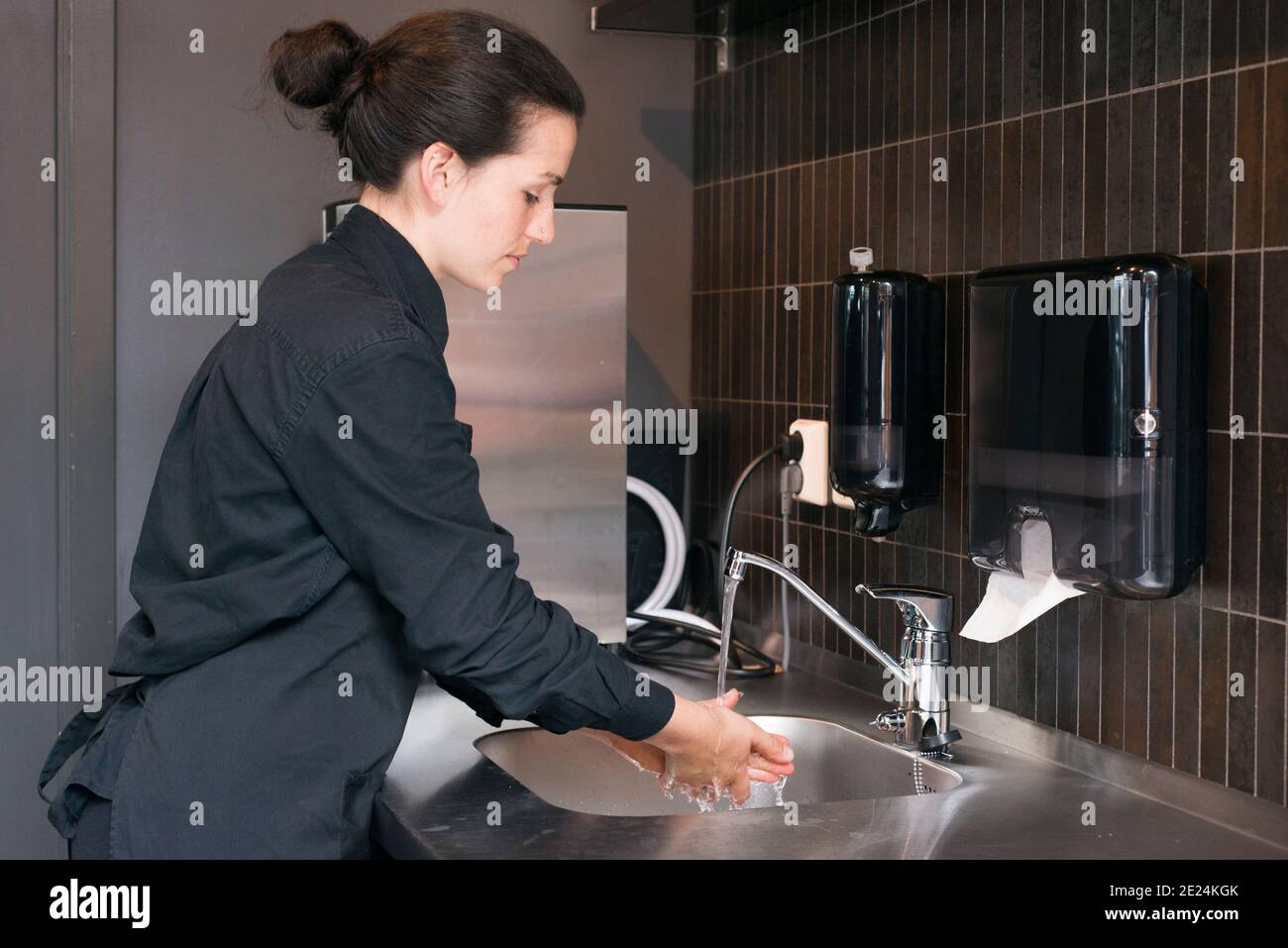 Donna che lava le mani sul lavoro Foto Stock