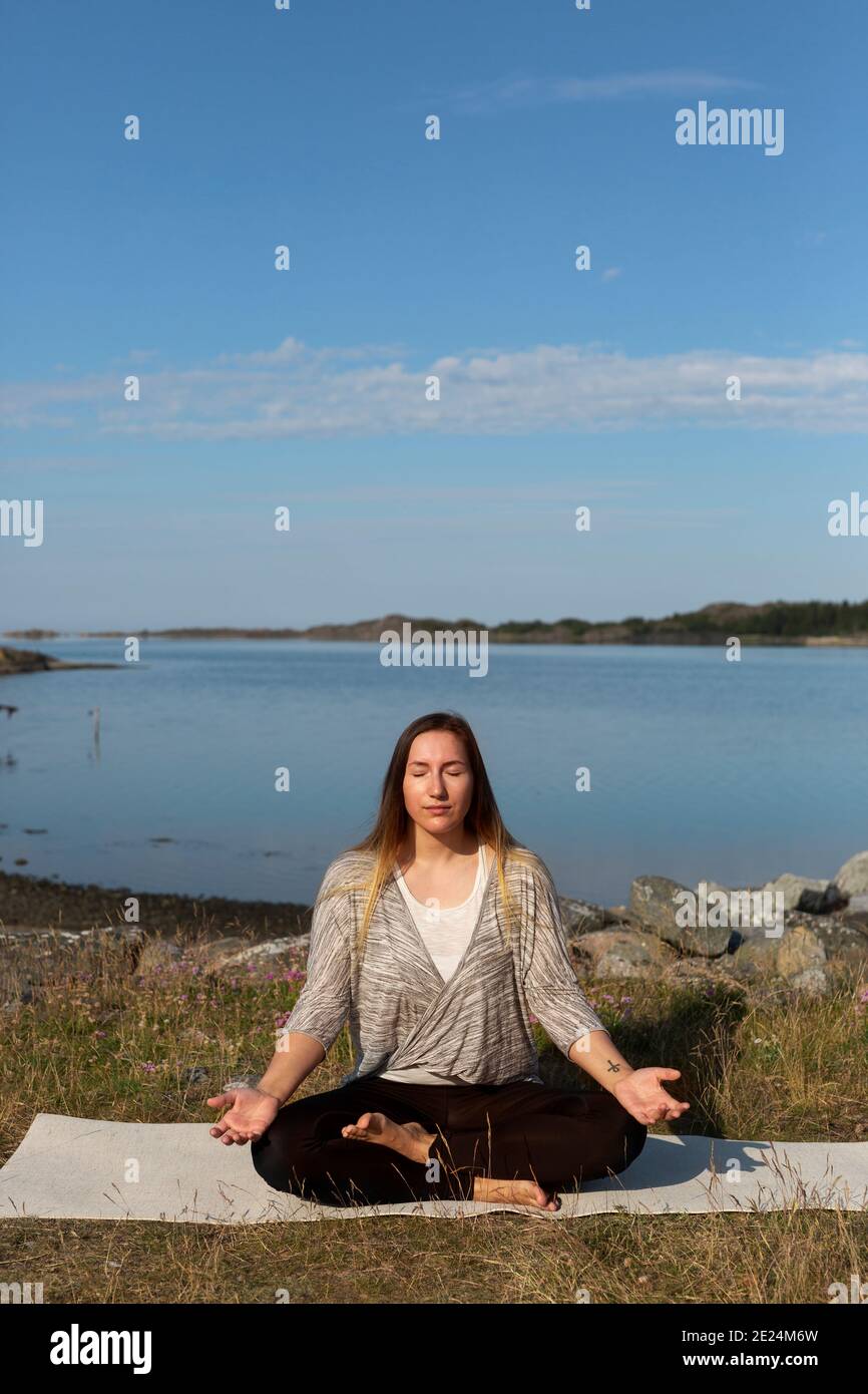 Donna meditando in mare Foto Stock