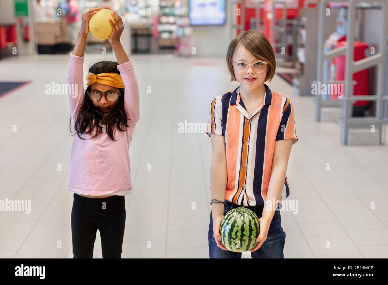 Ragazza nel supermercato che tiene frutta Foto Stock