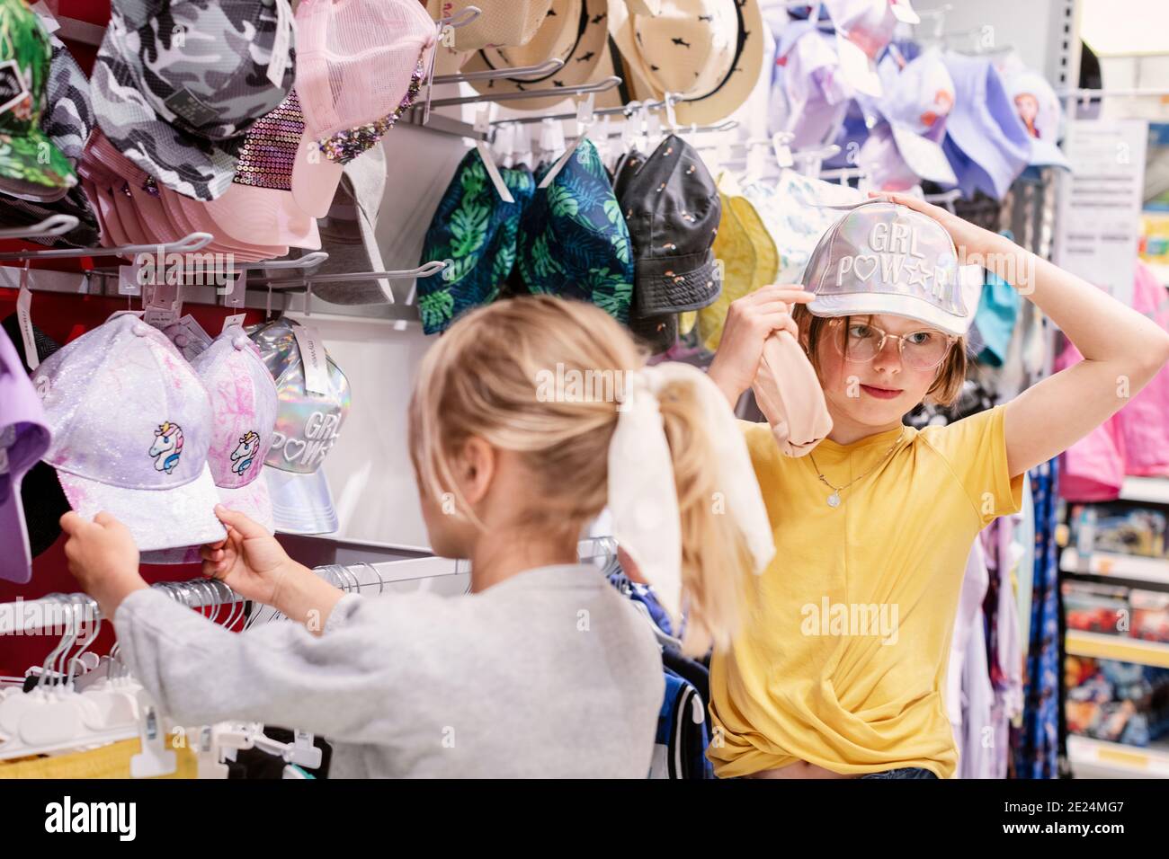 Ragazze che cercano cappelli da baseball in negozio Foto Stock