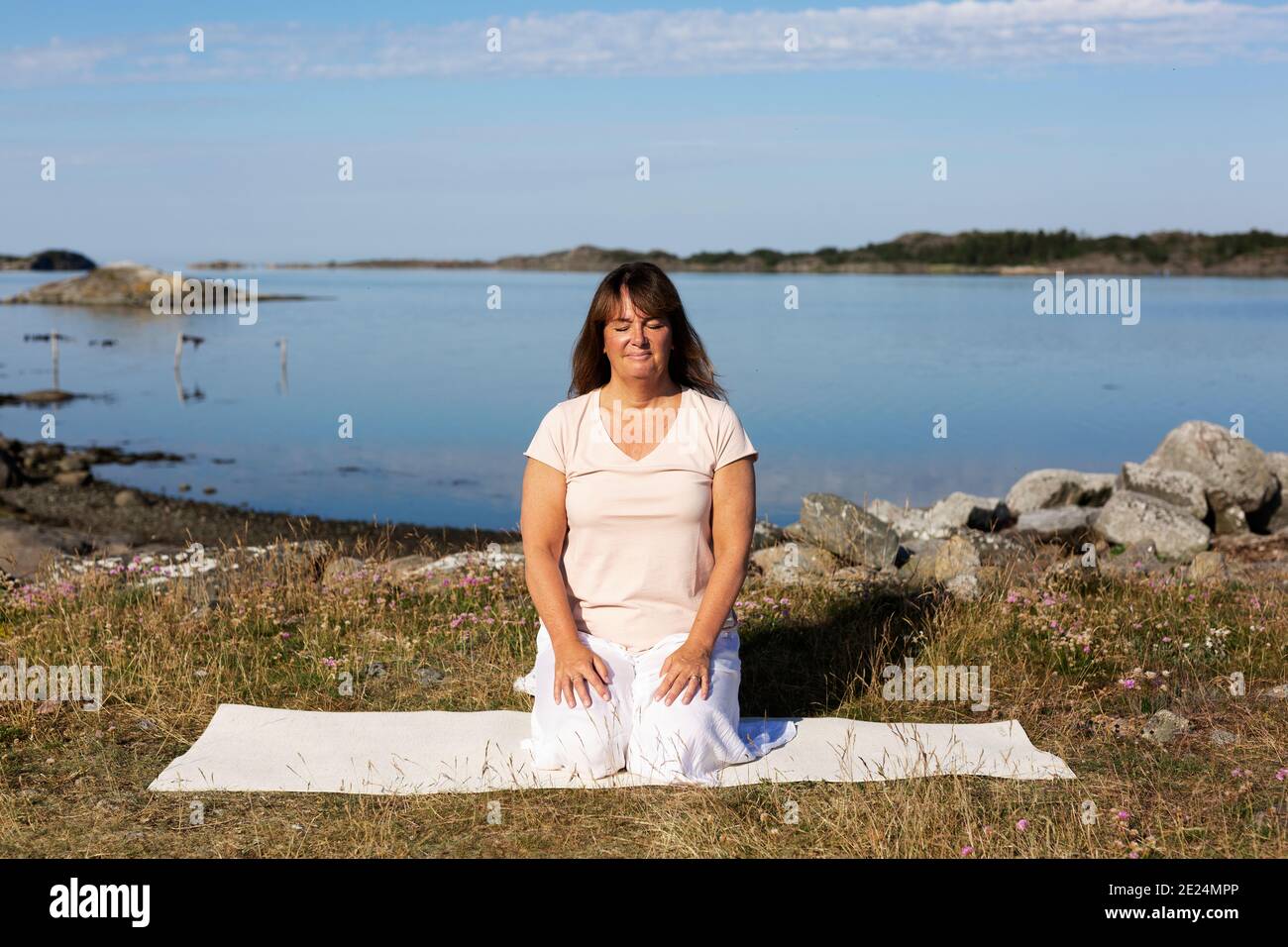 Donna meditando in mare Foto Stock