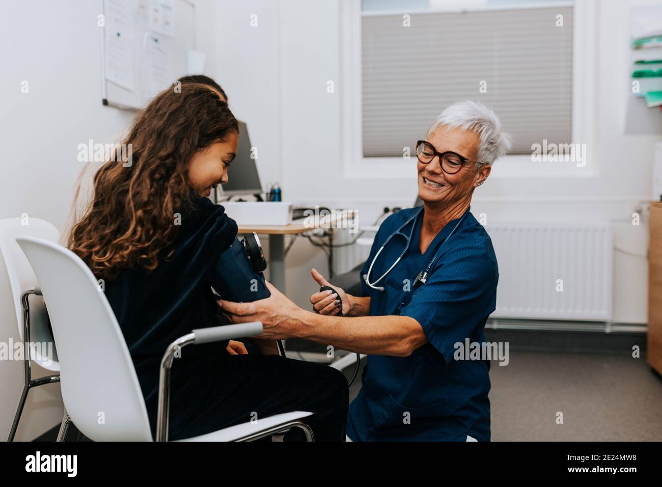 Il medico le ragazze di controllo della pressione del sangue Foto Stock