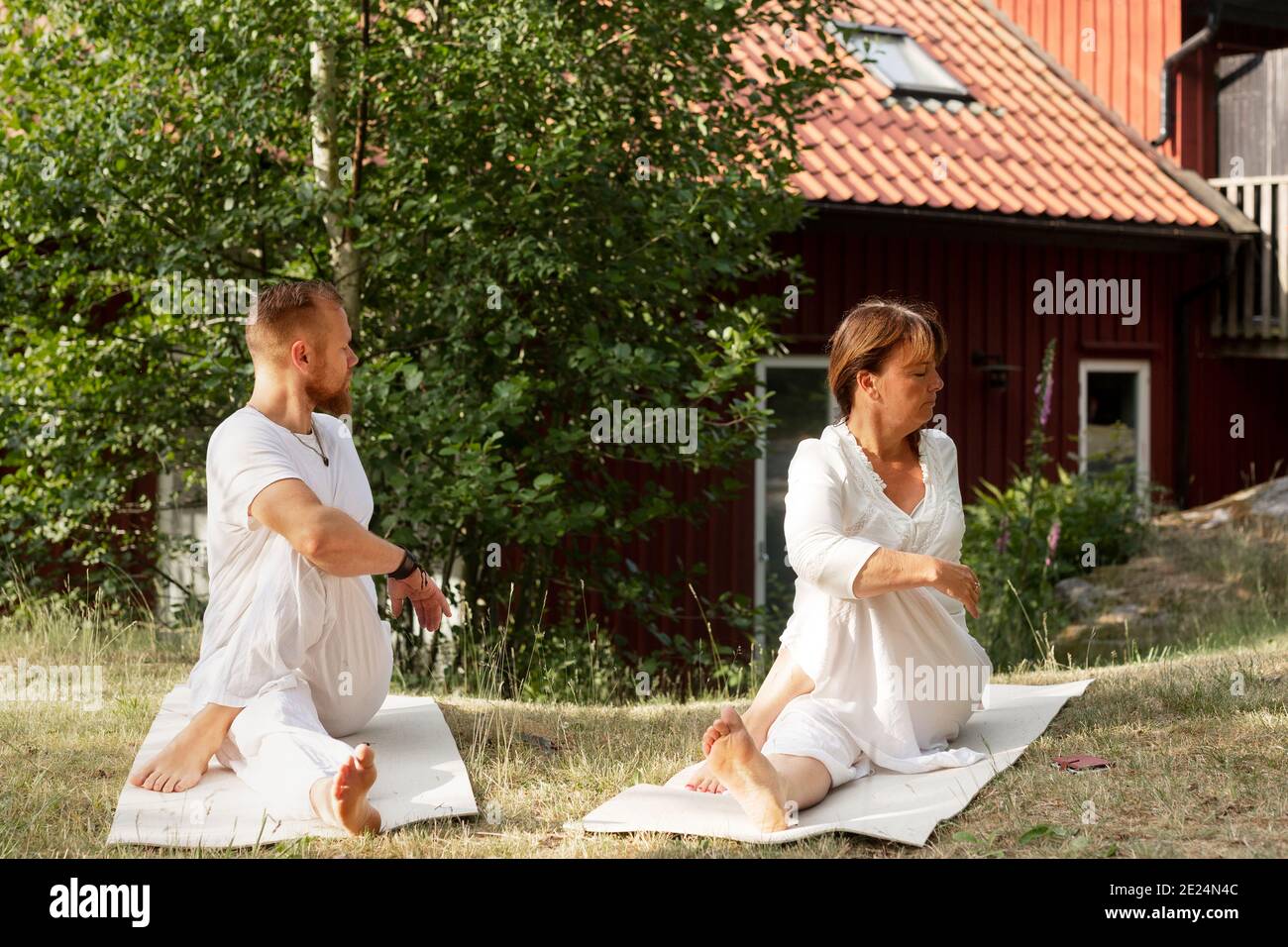 L'uomo e la donna praticano lo yoga in estate Foto Stock