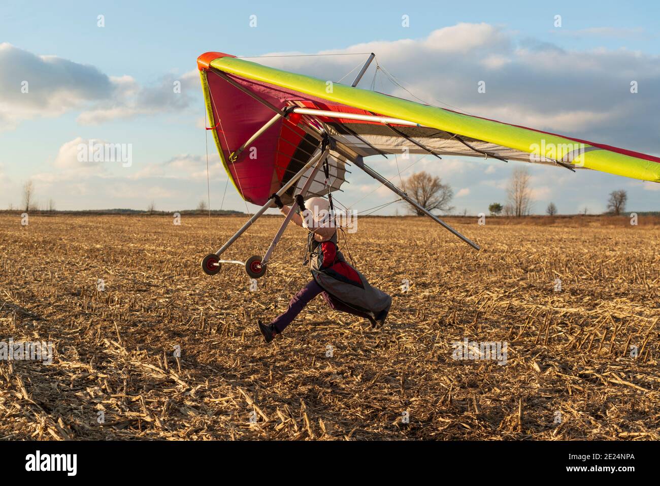 Imparare a volare. Il pilota studentesco per principianti corre velocemente con l'ala deltaplano. Foto Stock