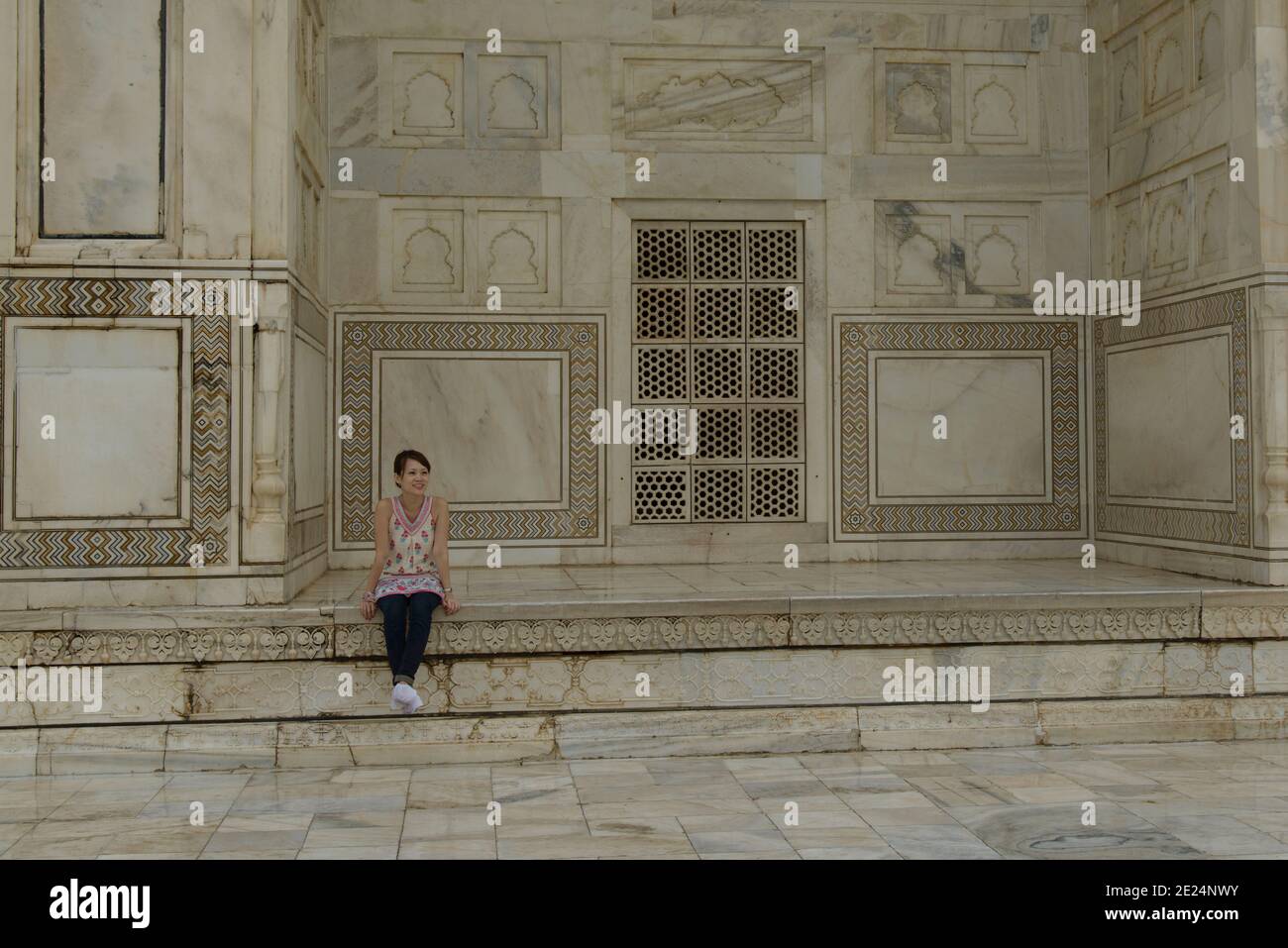 Donna seduta su un muro al Taj Mahal, Agar, Uttar Pradesh, India Foto Stock