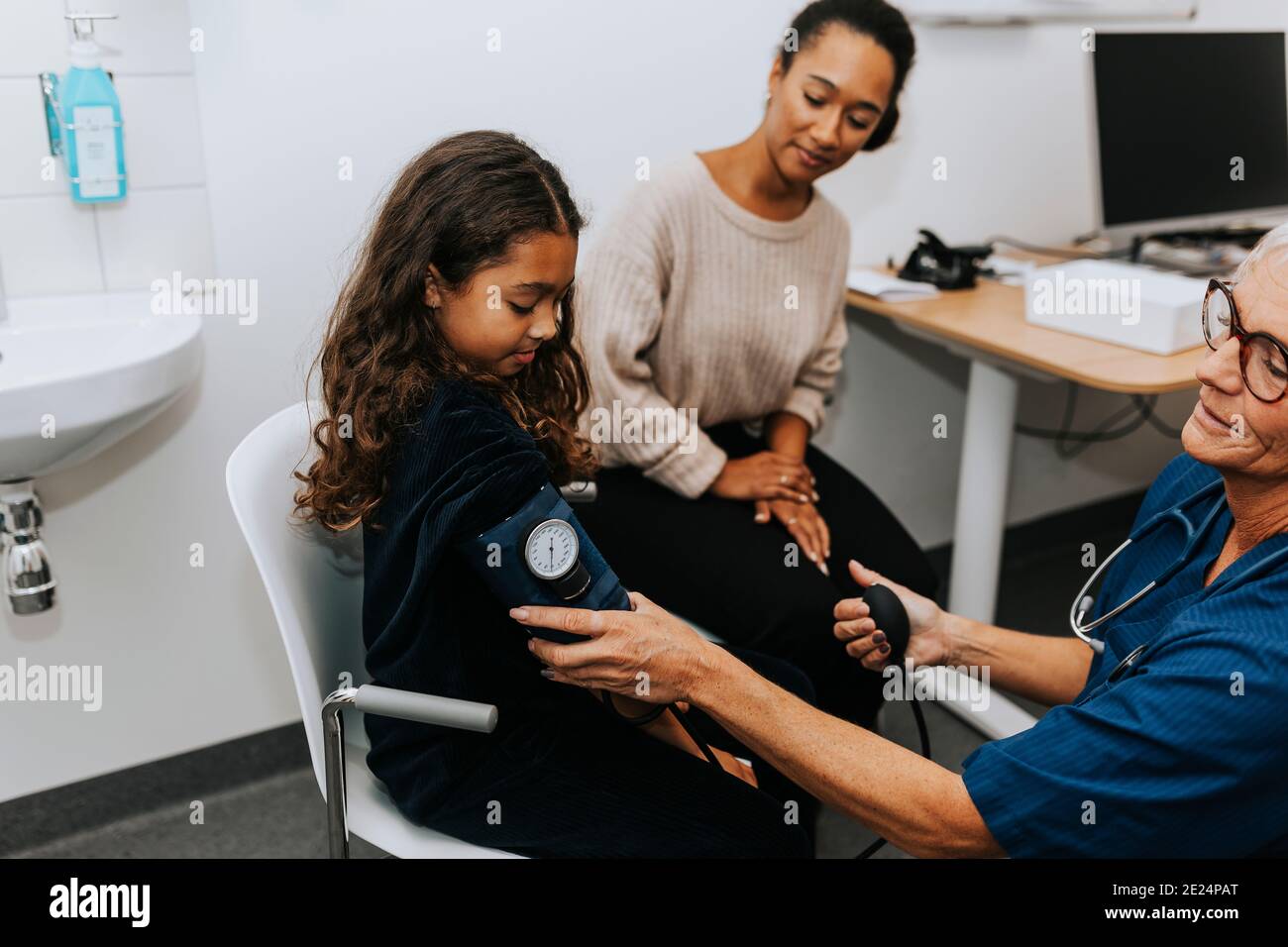 Il medico le ragazze di controllo della pressione del sangue Foto Stock