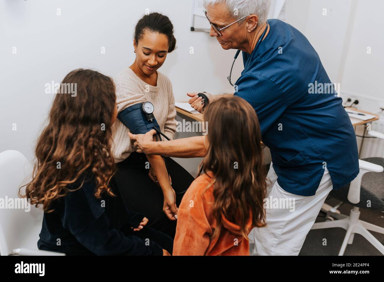 Medico che controlla la pressione sanguigna delle donne Foto Stock