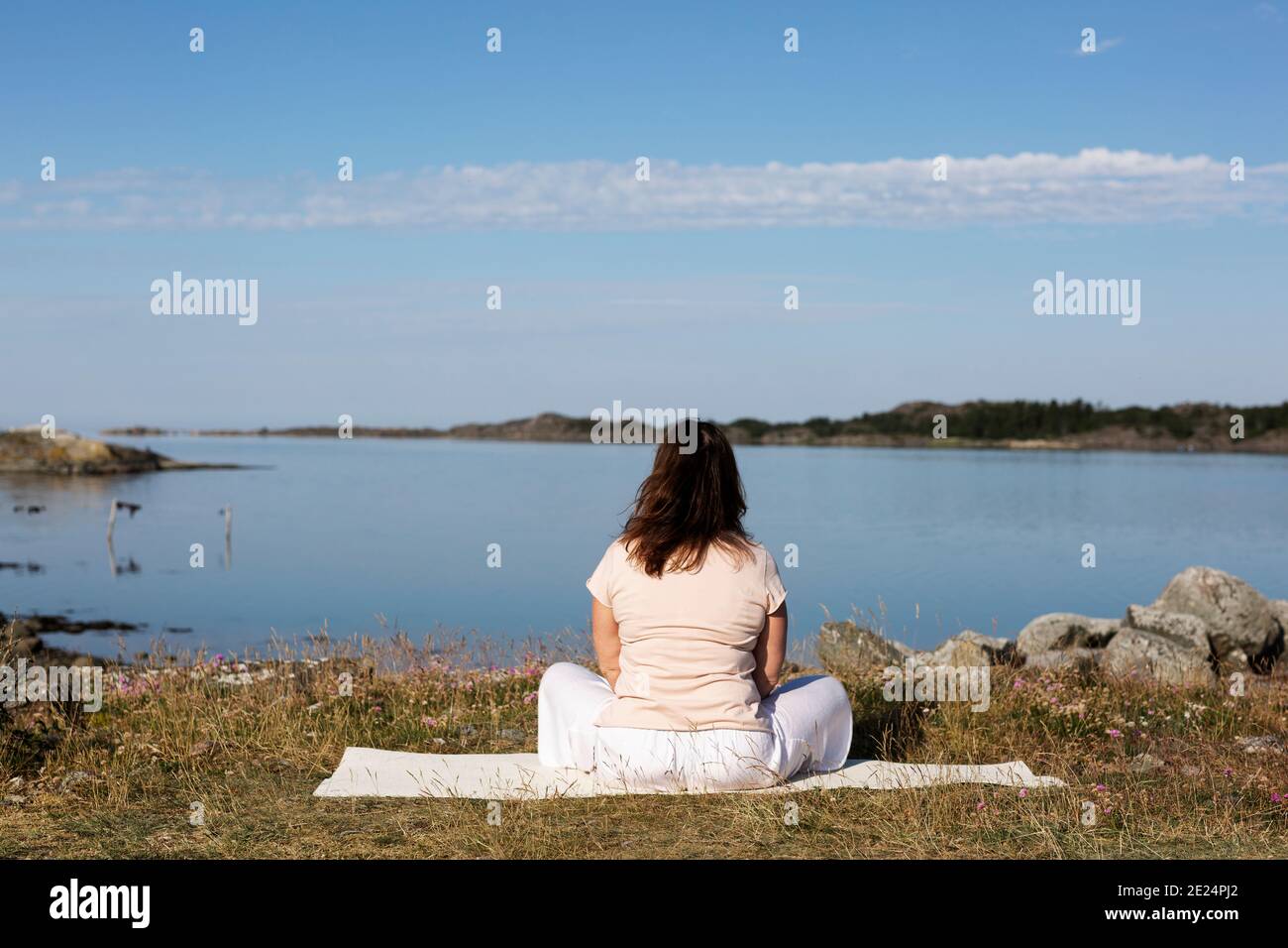 Donna meditando in mare Foto Stock