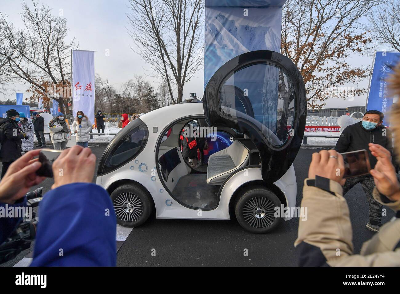 Changchun, la provincia cinese di Jilin. 12 gennaio 2021. Le persone scattano foto di un veicolo senza conducente durante una gara invernale di sfida su un veicolo senza conducente in un parco forestale a Changchun, nella provincia di Jilin, nella Cina nord-orientale, il 12 gennaio 2021. La competizione è iniziata qui martedì, con l'obiettivo di controllare le prestazioni di quei veicoli senza conducente in condizioni meteorologiche avverse in inverno. Credit: Zhang Nan/Xinhua/Alamy Live News Foto Stock