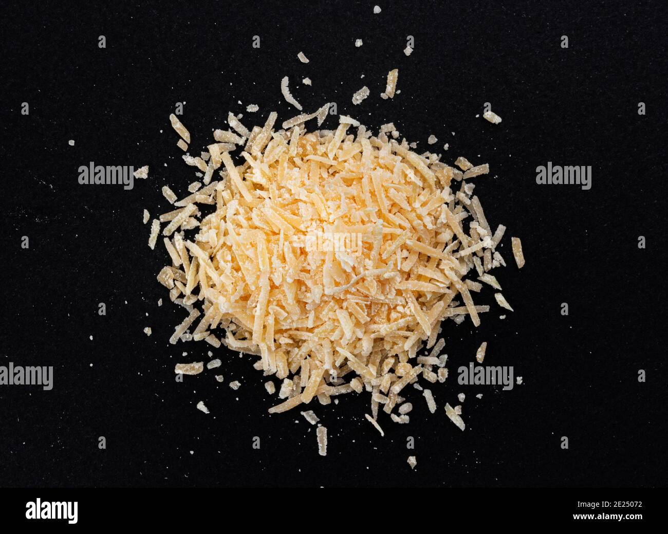 Parmigiano grattugiato su fondo nero, primo piano parmigiano Foto Stock