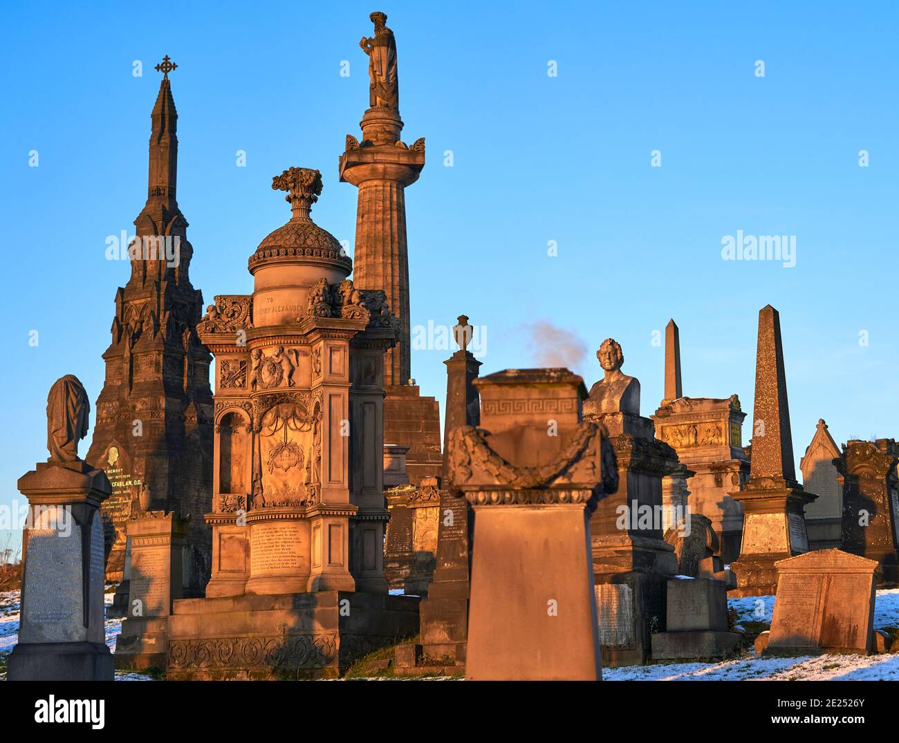 Primo piano di un gruppo di lapidi e monumenti sono saliti in un giorno di inverni innevati nella necropoli di Glasgow. Foto Stock