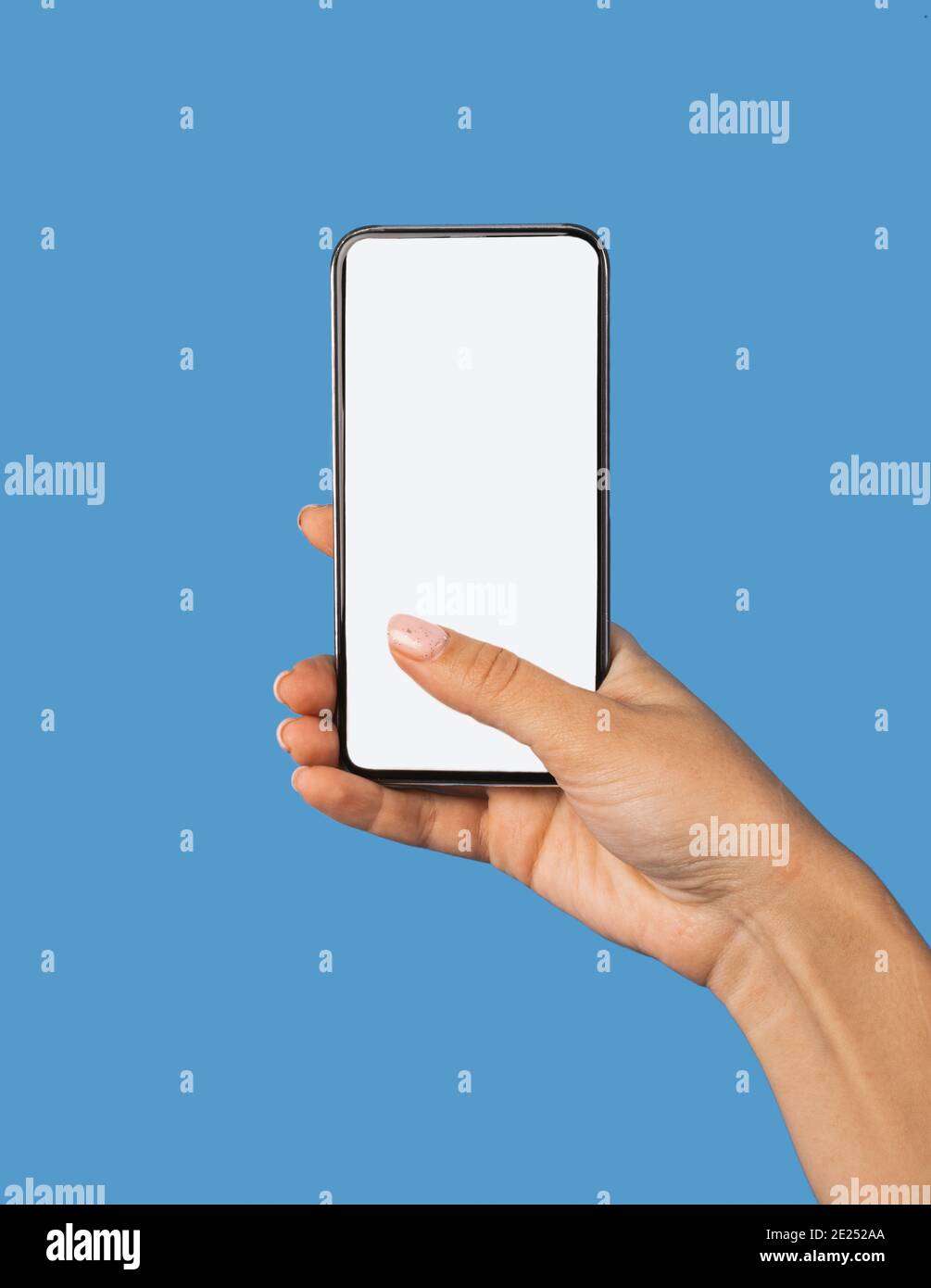 Telefono femminile con schermo vuoto su sfondo blu Foto Stock