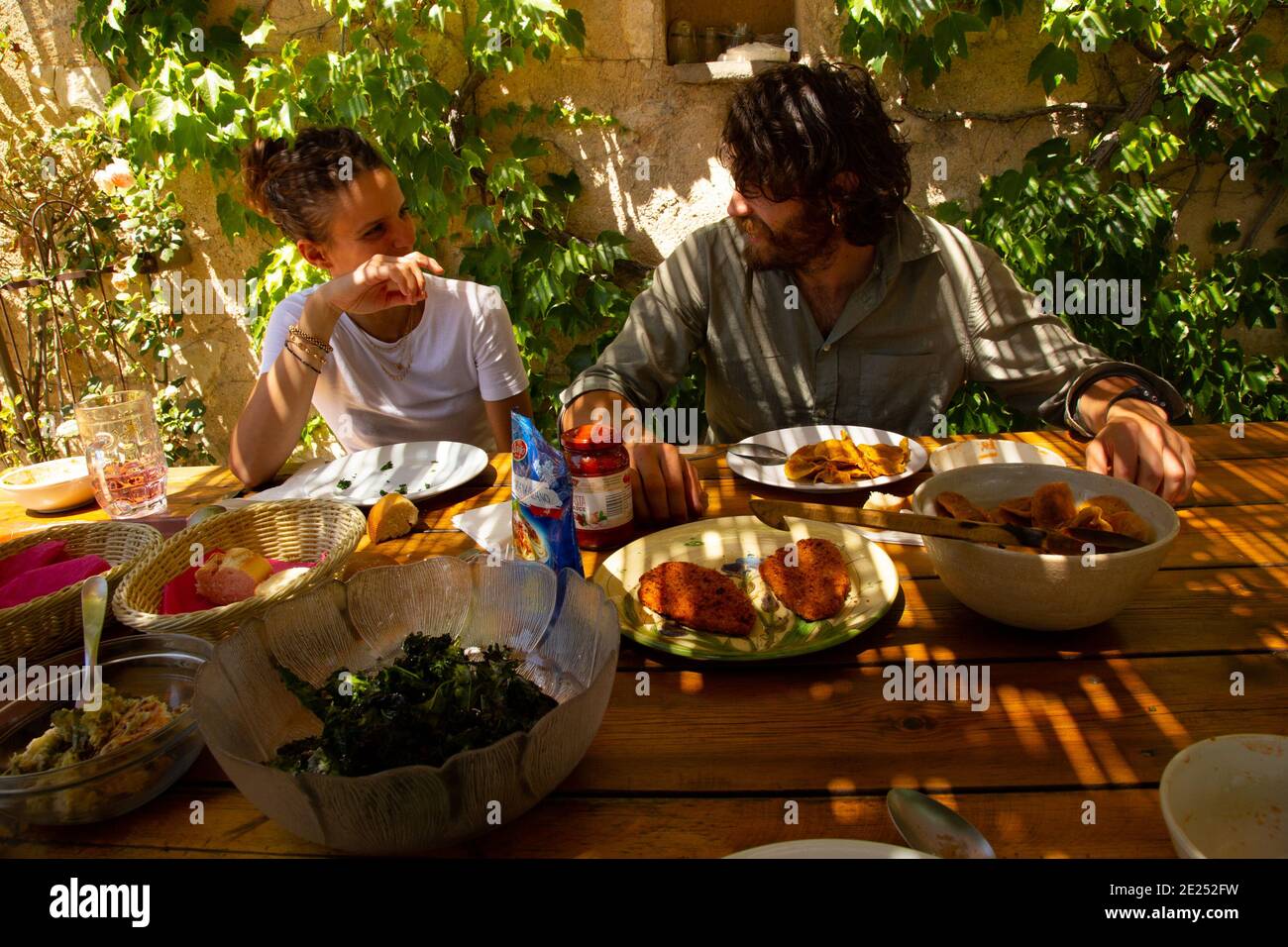 Una giovane coppia che gusta un pasto mediterraneo. Foto Stock