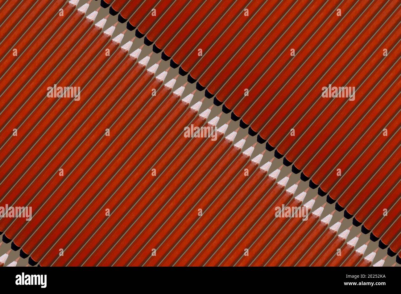 Modello di matite arancioni su sfondo marrone Foto Stock