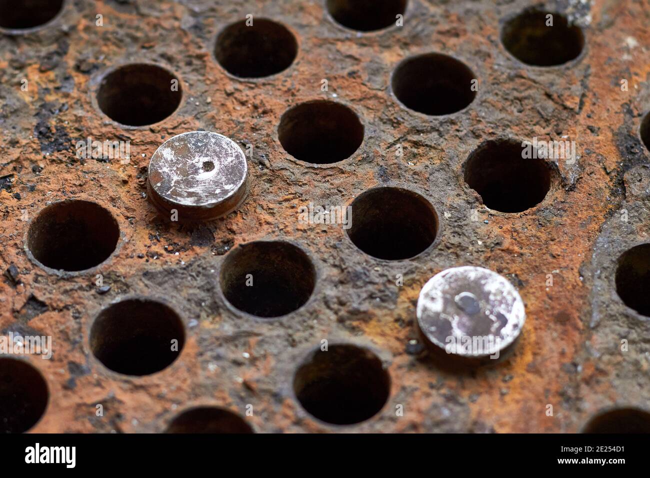 Piastra tubiera o piastra dello scambiatore di calore selettivo per la chiusura della caldaia sfondo di messa a fuoco scollegato silenziato tubi di tenuta ostruiti con tappi in acciaio con insolubile Foto Stock