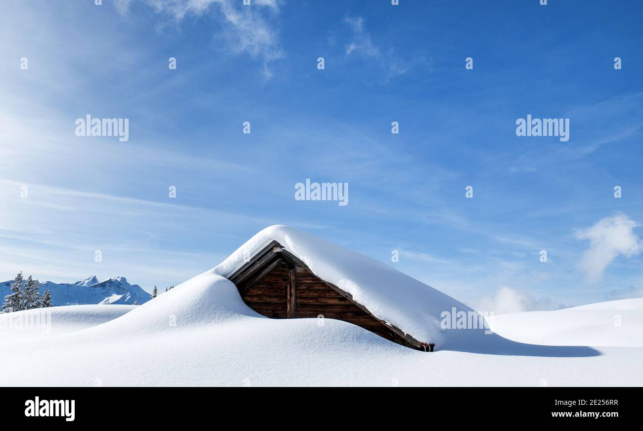 Un fienile alpino dopo una notte di neve fresca mostra come la natura artistica può essere. Foto Stock