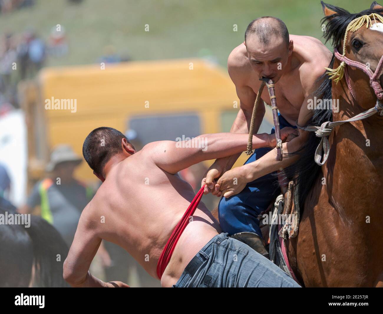 Un concorrente è stato spinto dal cavallo. Er Enish o Oodarysh, lottando a cavallo, uno sport equestre tradizionale. Festa popolare e Sport sul Suu Foto Stock