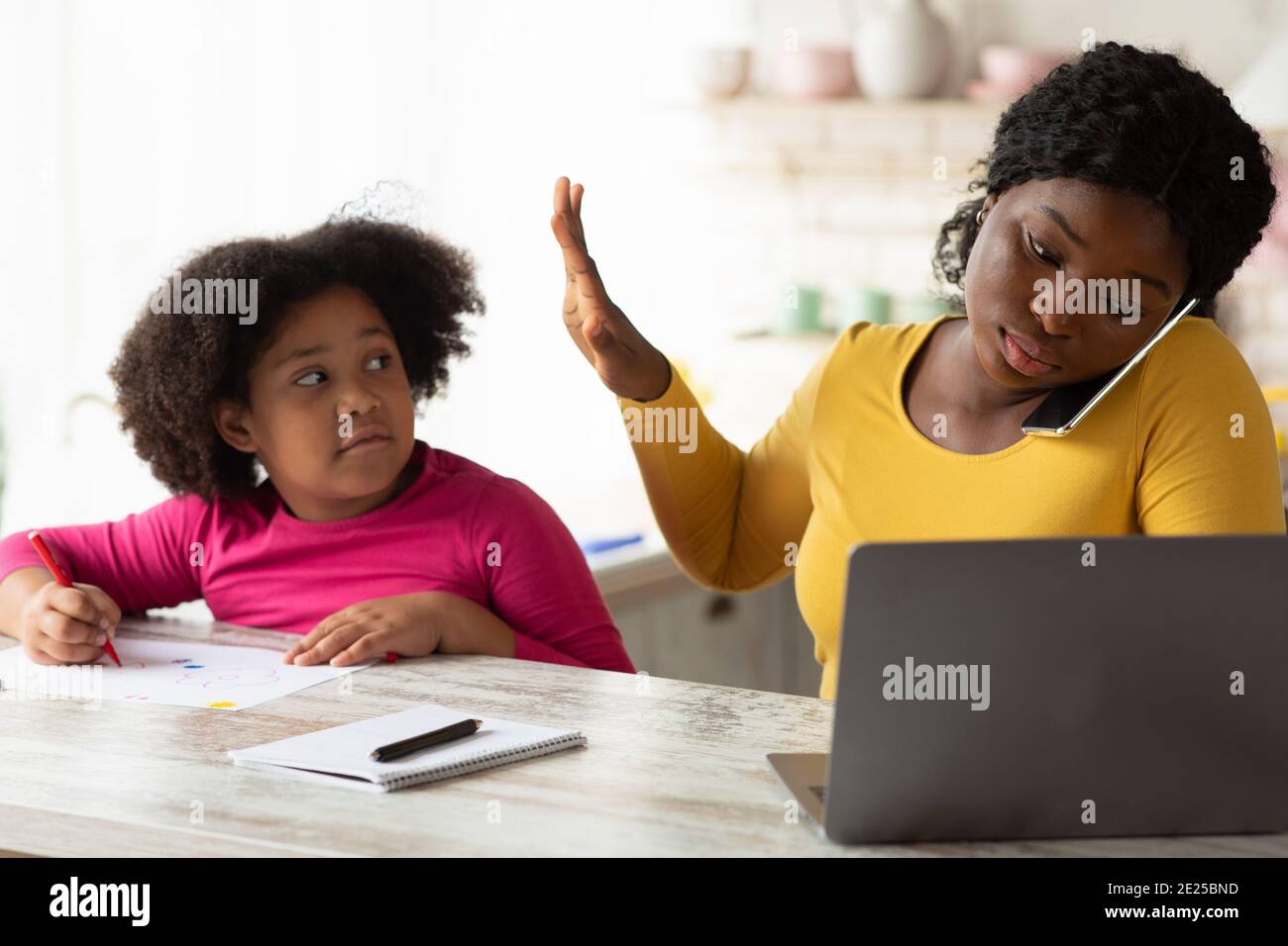 Impegnato lavoro Africano-americana Madre ignorando la sua piccola figlia chiedere Per attenzione Foto Stock