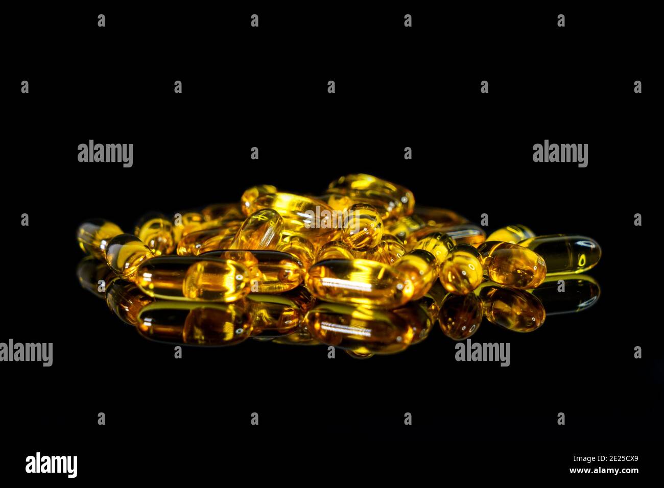 Capsule di olio di pesce su sfondo nero. Tema della salute. Foto Stock