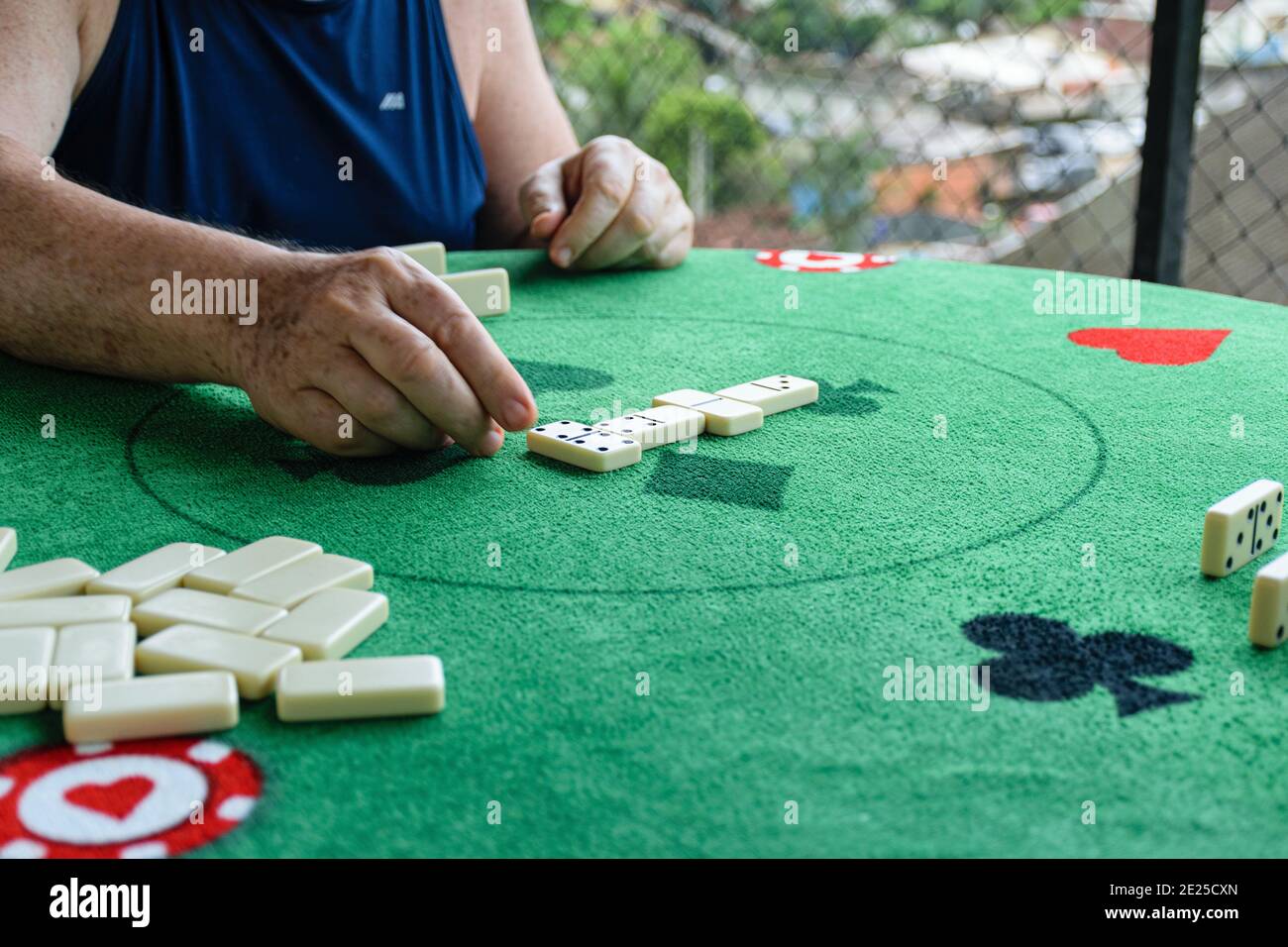 Uomo anziano piazzando un doppio 4 nel gioco domino. Foto Stock