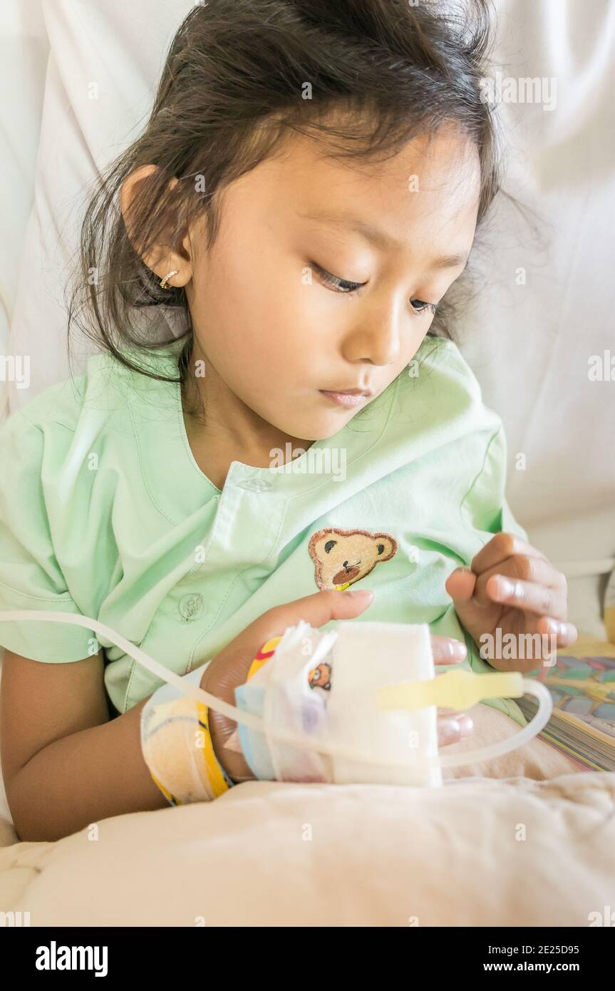 Asian ethnal Little Girl Feeling depressa impaziente per infusione in ospedale Foto Stock