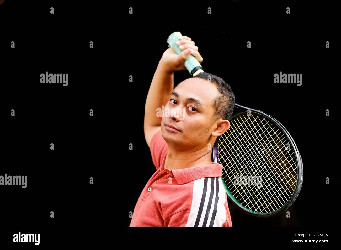 ritratto di sano e in forma asiatico etnico giovane adulto maschio reggendo la racchetta da tennis Foto Stock