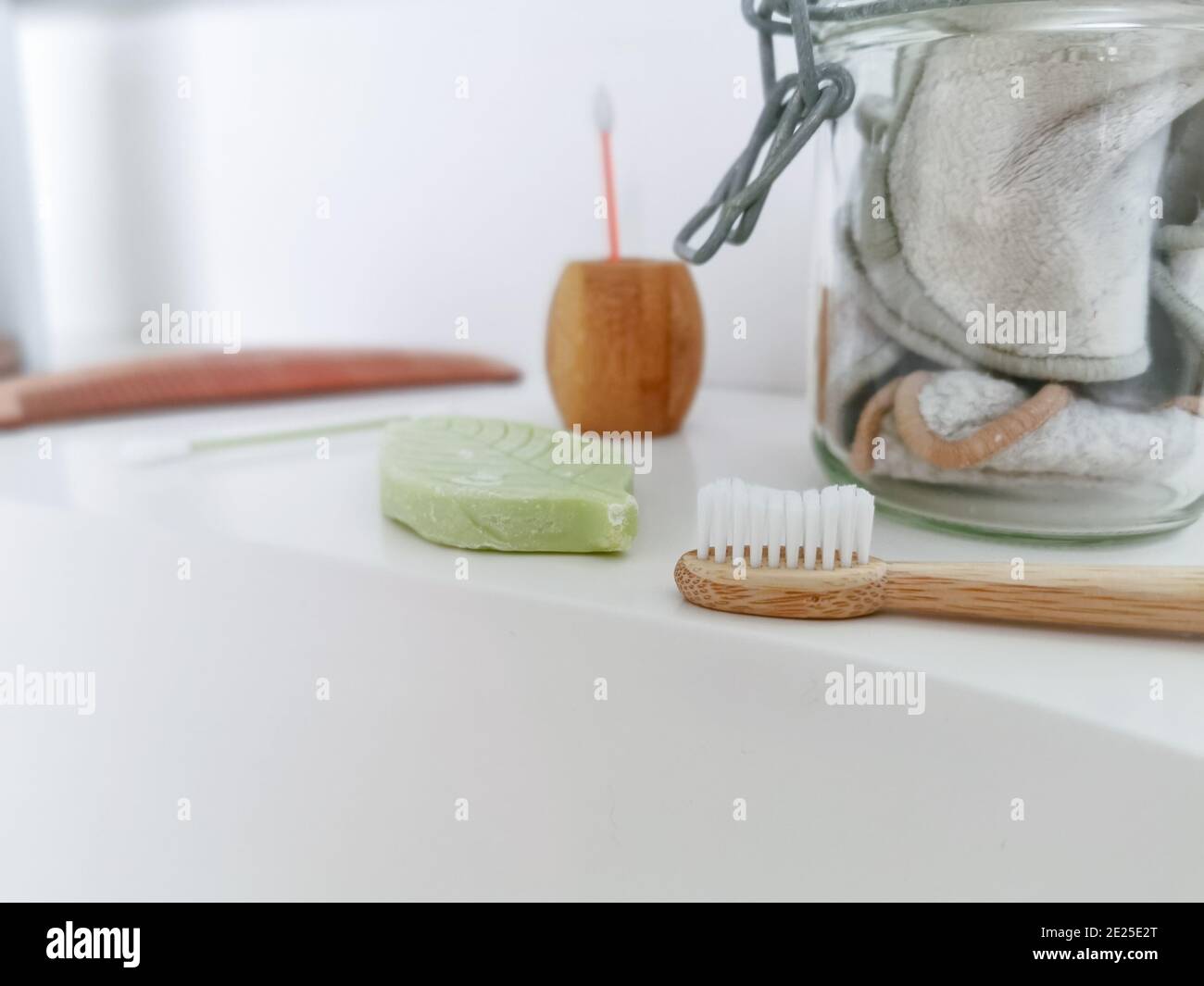 Concetto di bagno senza sprechi con prodotti riutilizzabili e privi di plastica, come uno spazzolino da denti in bambù. Stile di vita sostenibile. Foto Stock