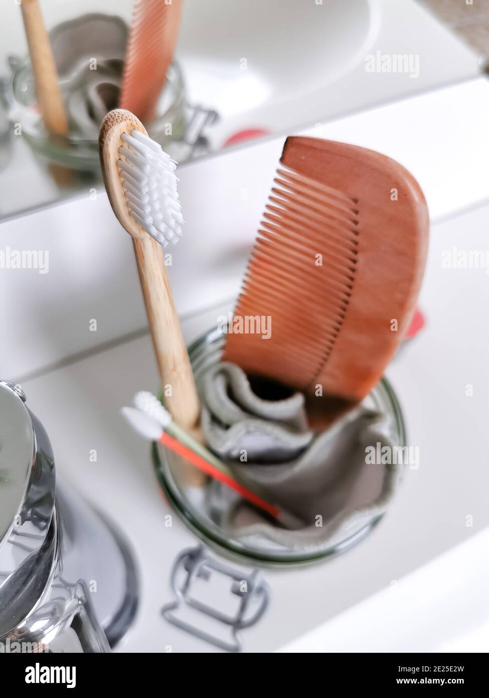 Concetto di bagno senza sprechi con prodotti riutilizzabili e privi di plastica, come ad esempio uno spazzolino da denti in bambù. Stile di vita sostenibile. Foto Stock