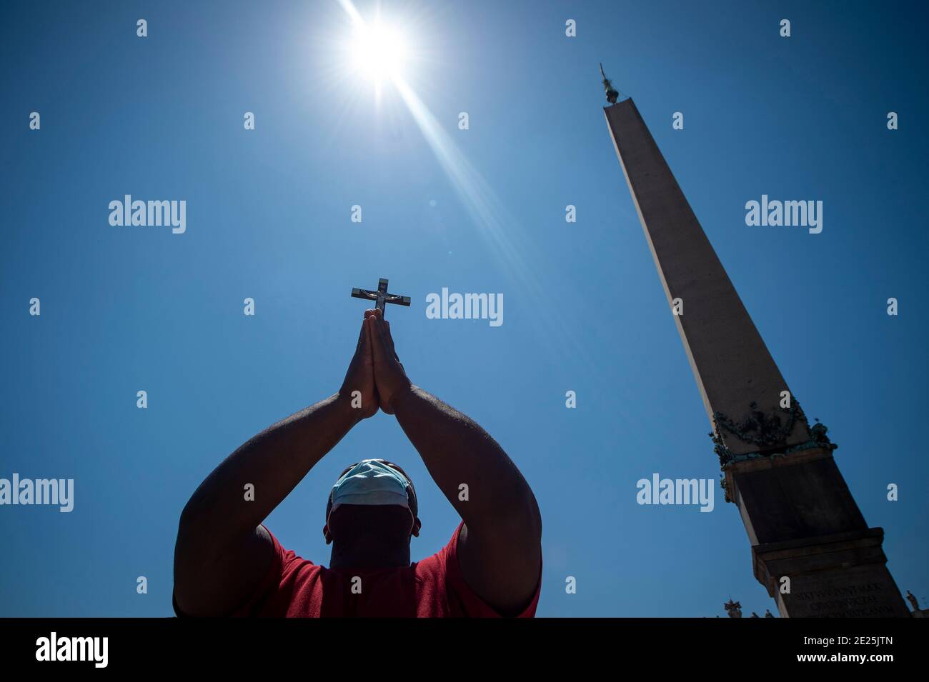 Un uomo solleva una croce durante la preghiera settimanale dell Angelus del Papa in Piazza San Pietro in Vaticano, il 28 giugno 2020 Foto Stock