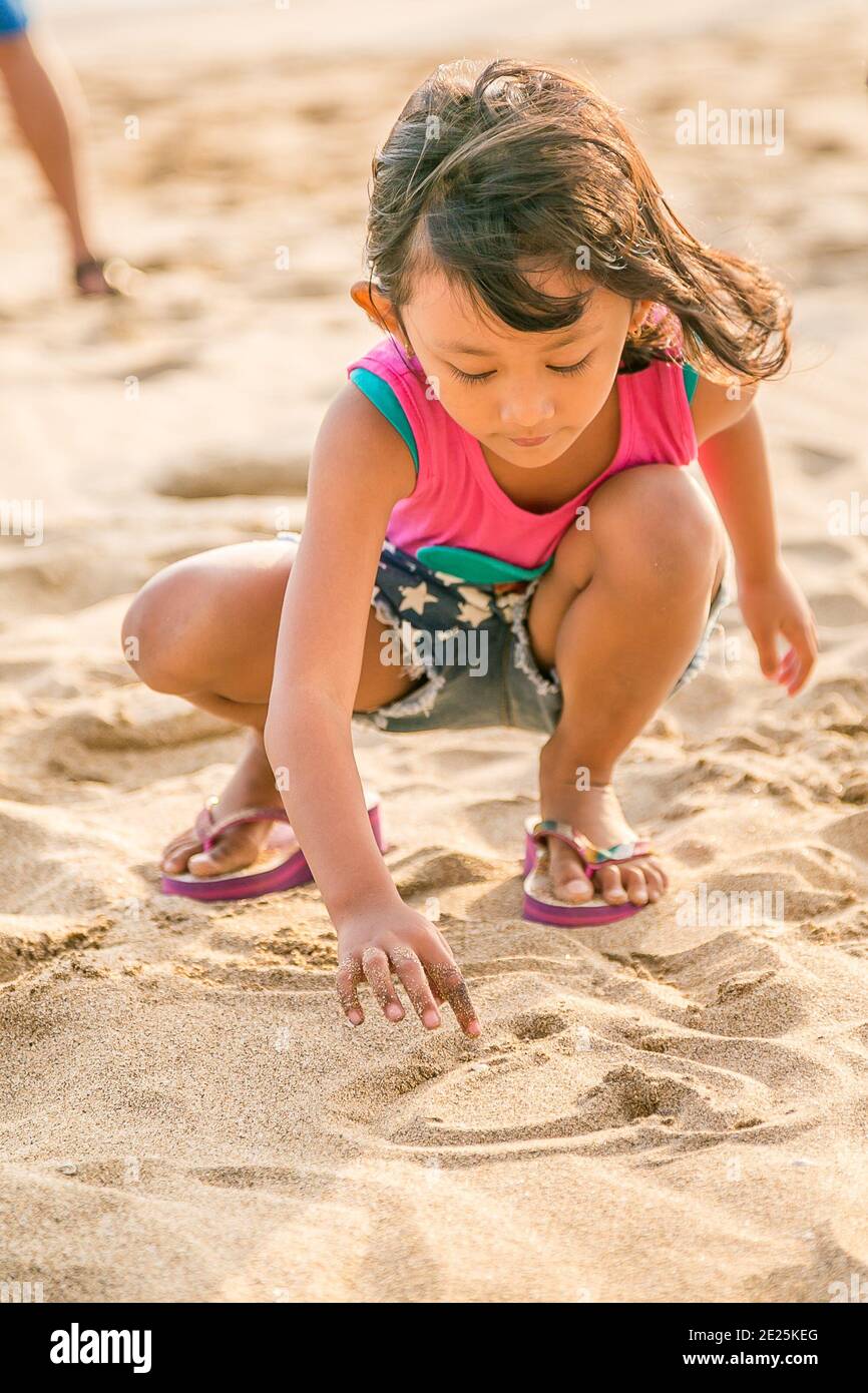 Etnico asiatico - Bambini Godetevi il disegno sulla sabbia di White Beach, concentratevi a portata di mano Foto Stock