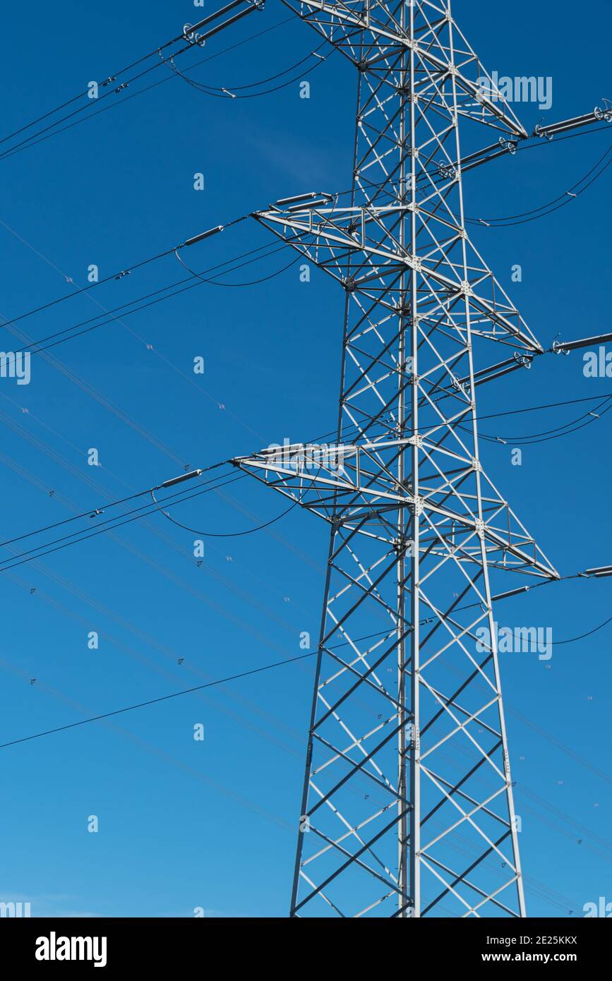 Polo di alimentazione per la trasmissione e la distribuzione dell'elettricità davanti al cielo blu Foto Stock