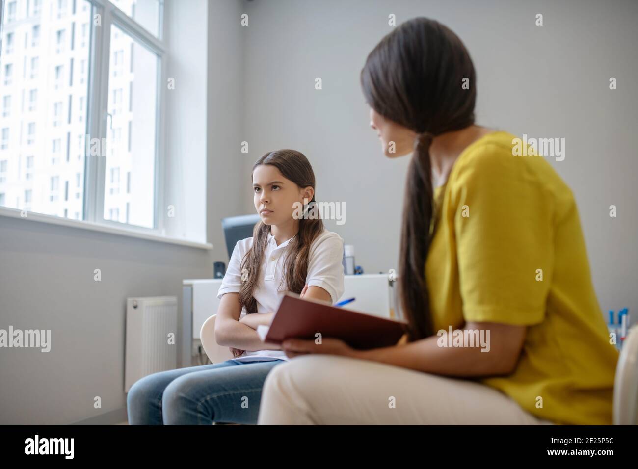 Silenziosa ragazza triste e donna con blocco note Foto Stock