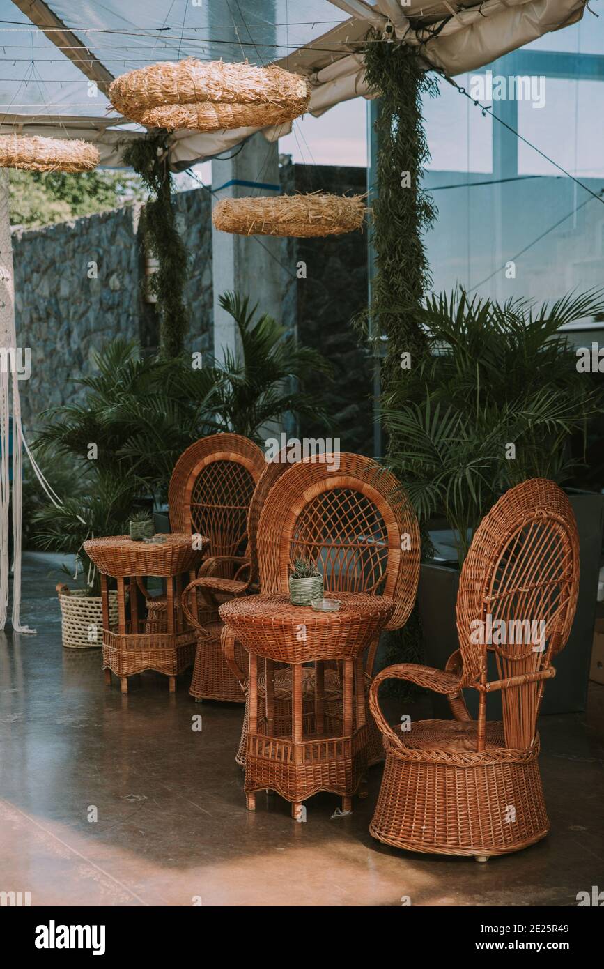 Poltrone e tavolo da giardino adornati con vasi, fiori e tessuti in pelle imitazione. Foto Stock