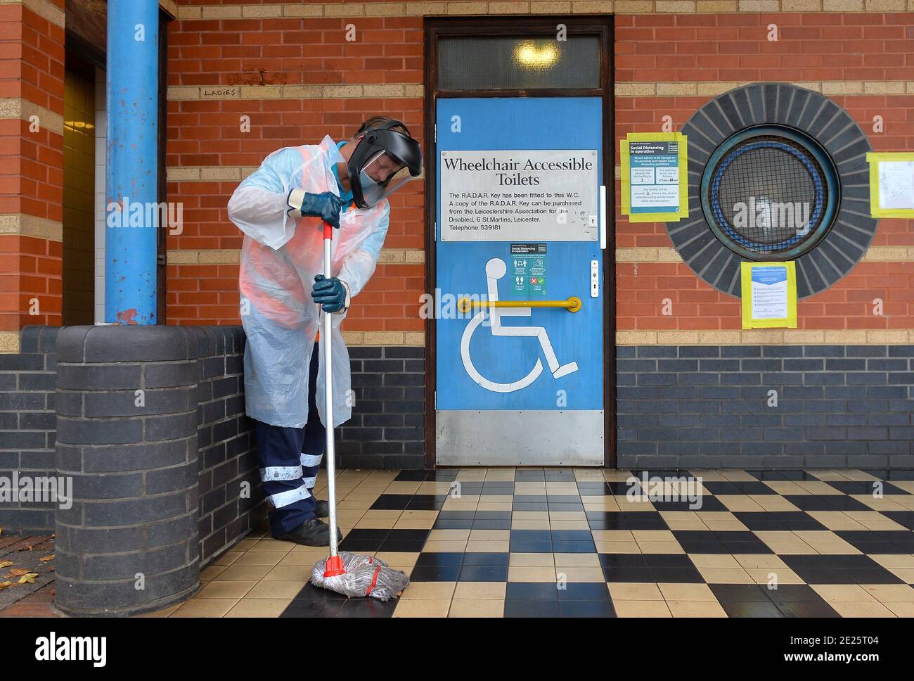 Un operaio del consiglio comunale pulisce i servizi igienici pubblici indossando la protezione personale Attrezzature nel centro di Leicester durante il Lockdown di Coronavirus Foto Stock