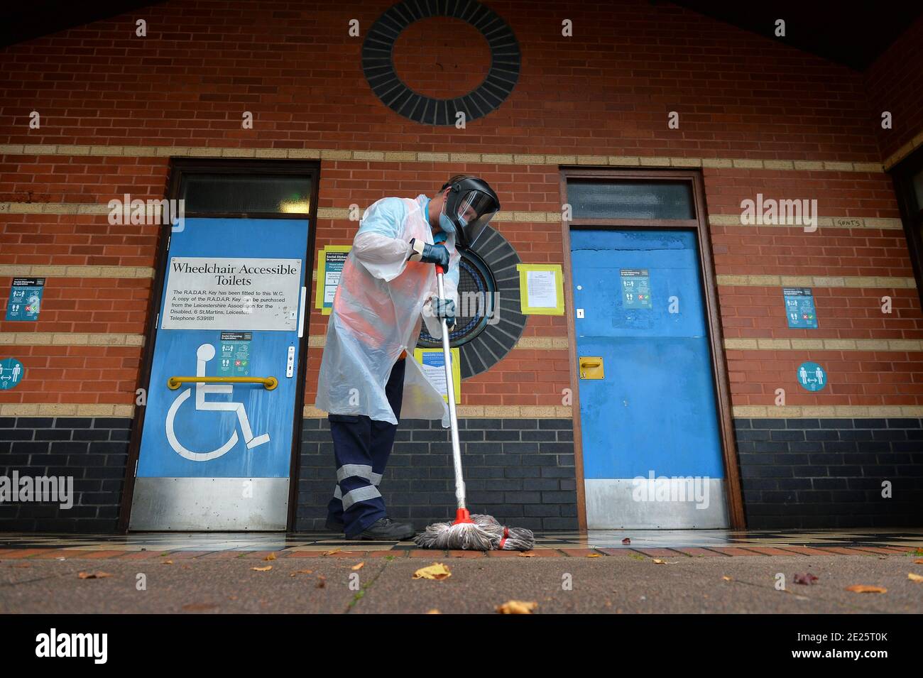 Un operaio del consiglio comunale pulisce i servizi igienici pubblici indossando la protezione personale Attrezzature nel centro di Leicester durante il Lockdown di Coronavirus Foto Stock
