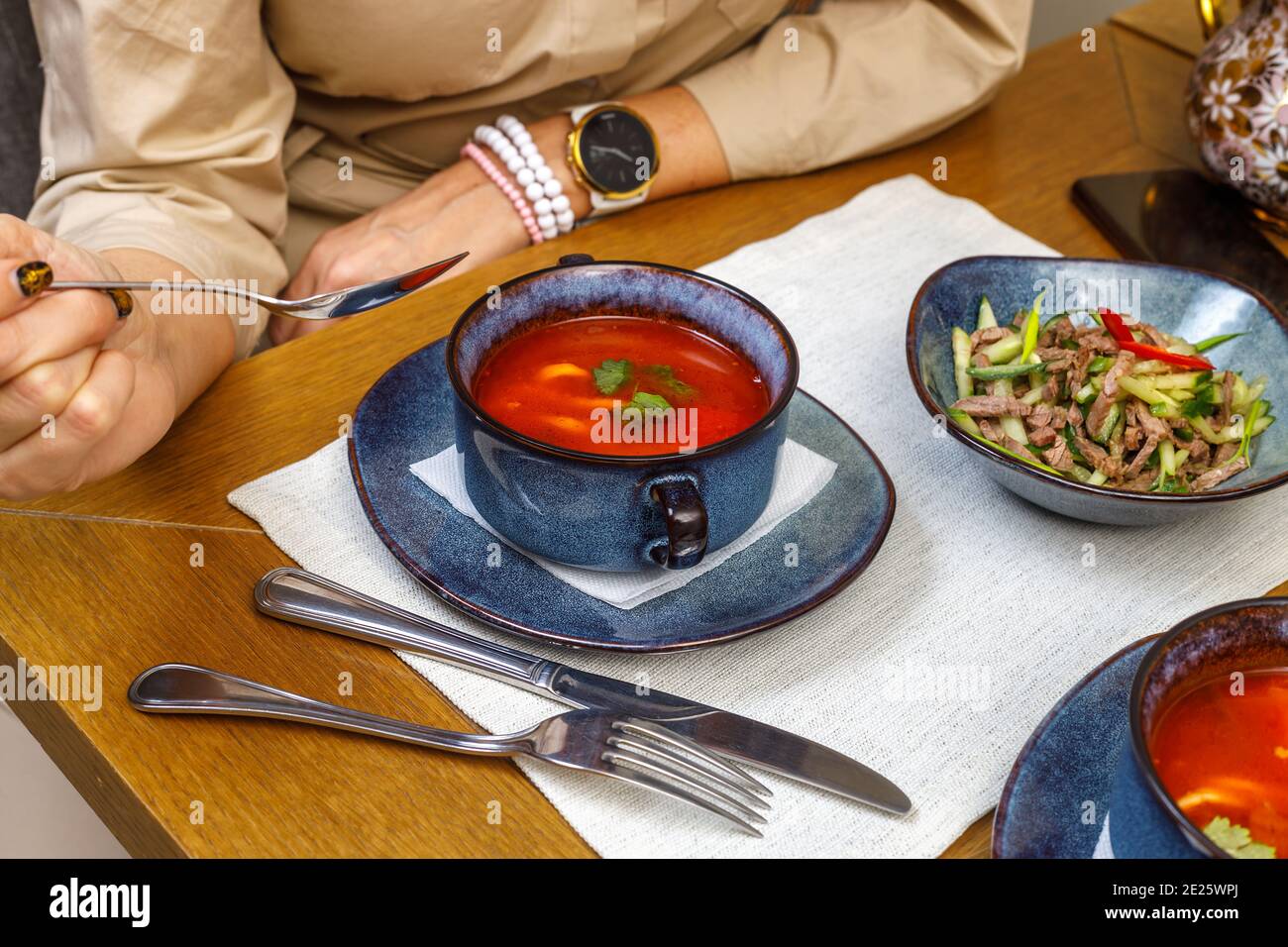 Un frammento del tavolo setting in un ristorante o in un caffè. Insalata, primo e secondo piatto. Il concetto del pranzo di affari. Foto Stock