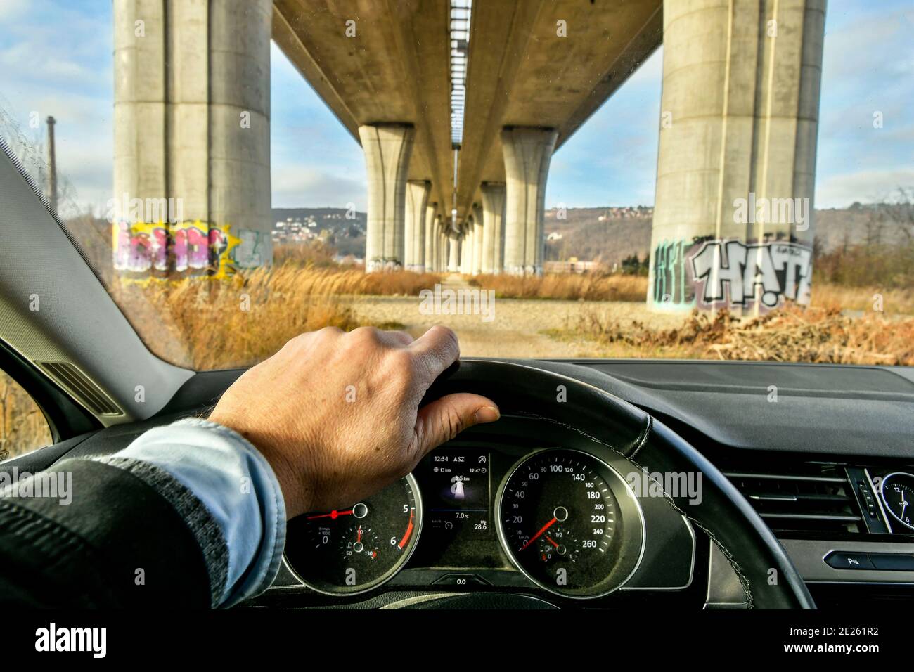 vista dal conducente dell'auto che passa sotto un ponte di cemento massiccio Foto Stock